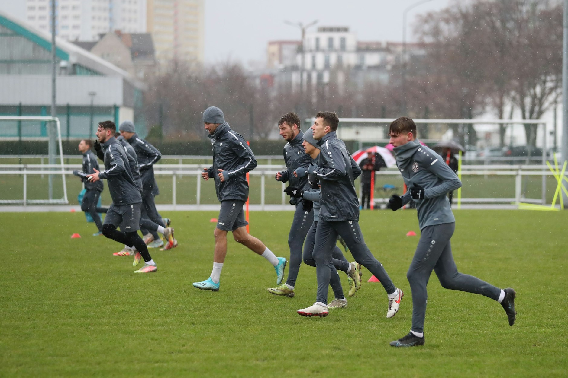 Bei Nieselregen laufen die Spieler des BFC Dynamo über den Rasen.
