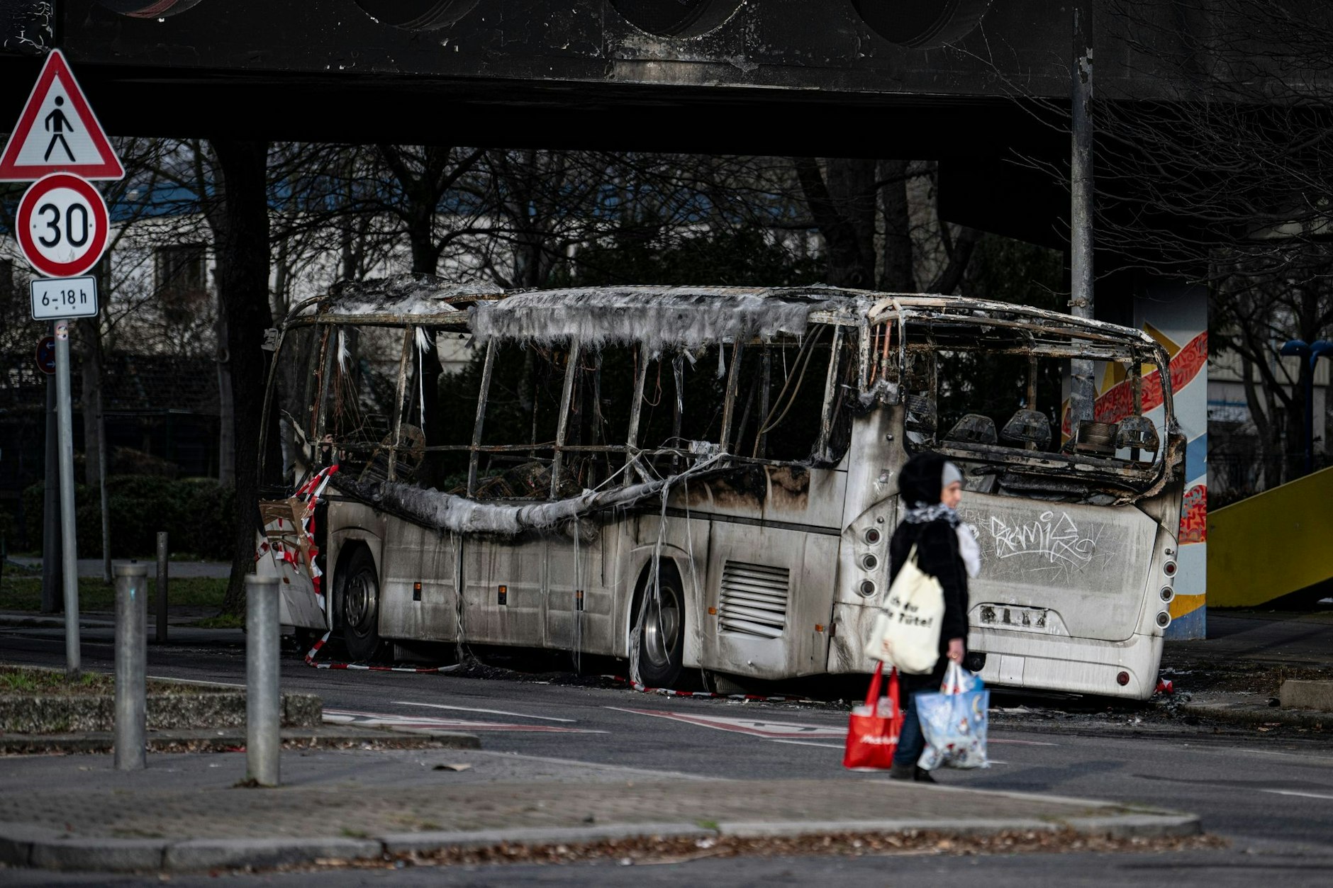Ein ausgebrannter Reisebus steht nach Krawallen in der Silvesternacht in einer Straße in Neukölln.