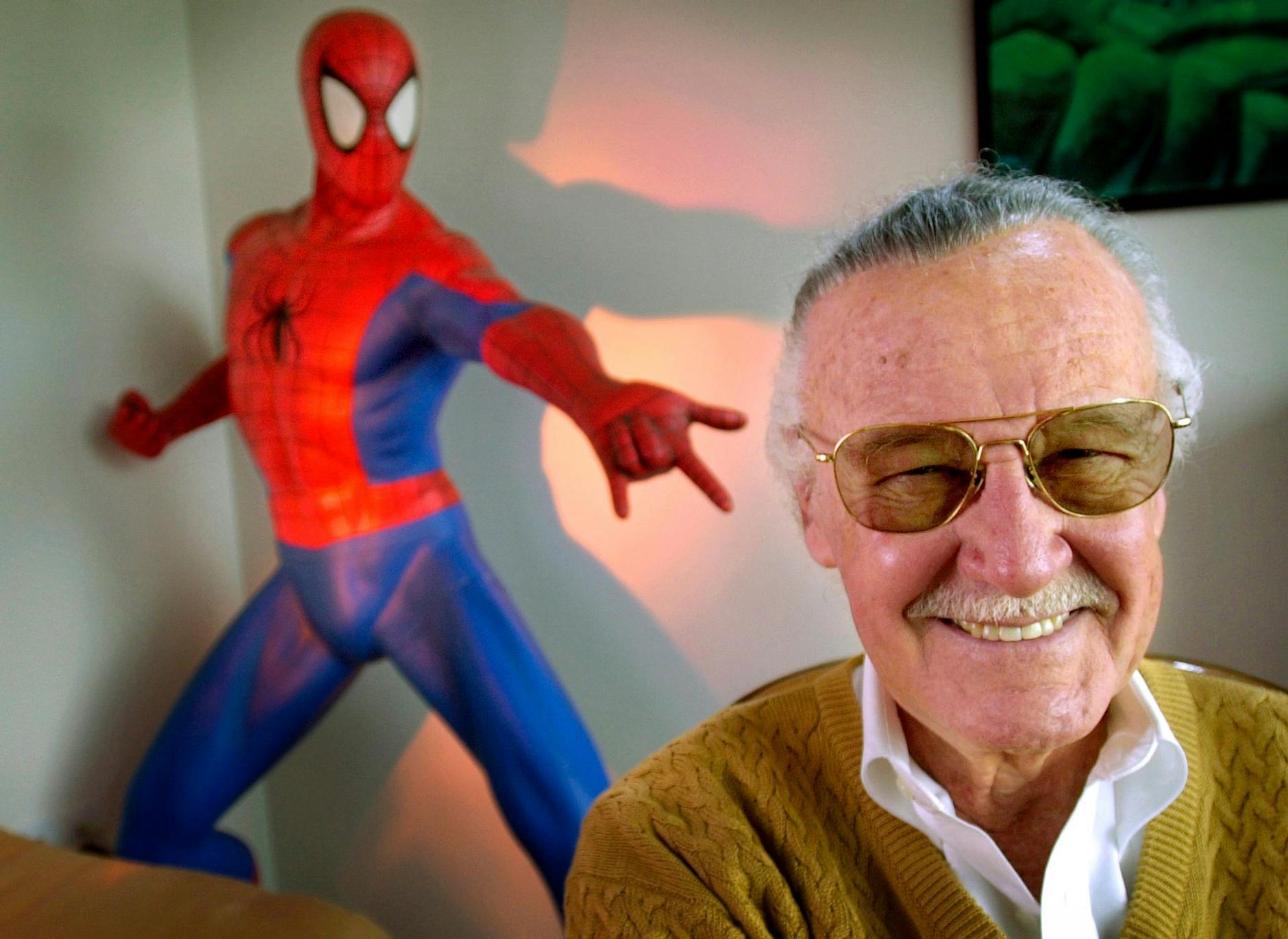 ARCHIV - Stan Lee, Comic-Autor aus den USA, lächelt in seinem Büro vor einer Spider-Man-Figur (2002).