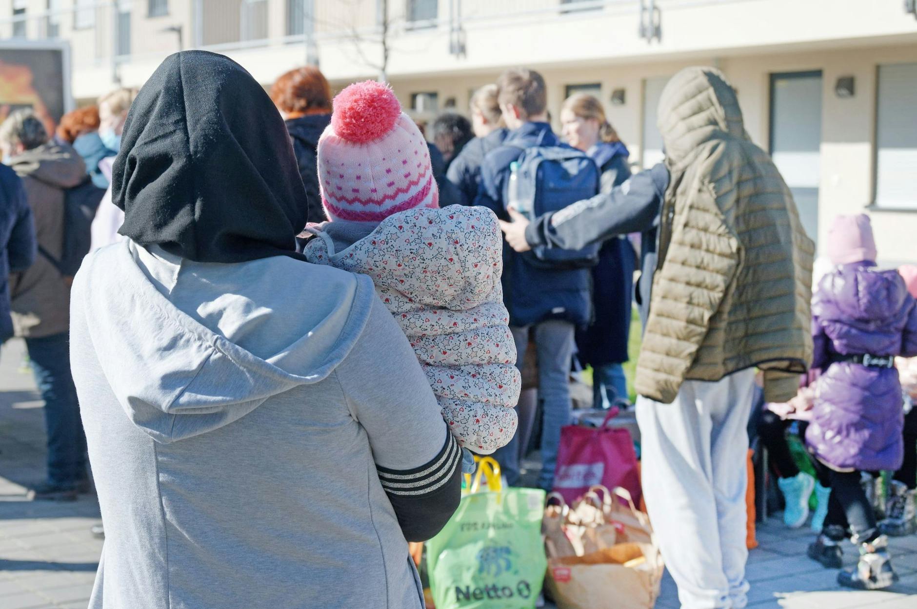 ARCHIV - Aus der Ukraine vertriebene Menschen stehen mit ihrem Gepäck vor einem Flüchtlingsheim in Köln.