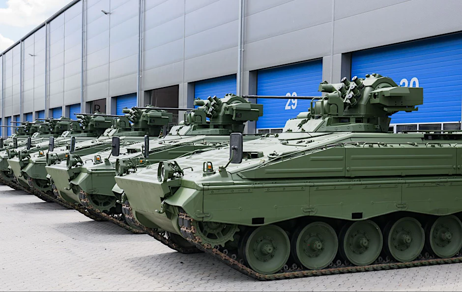 Wieder aufbereitete Marder-Schützenpanzer stehen vor einer Halle.