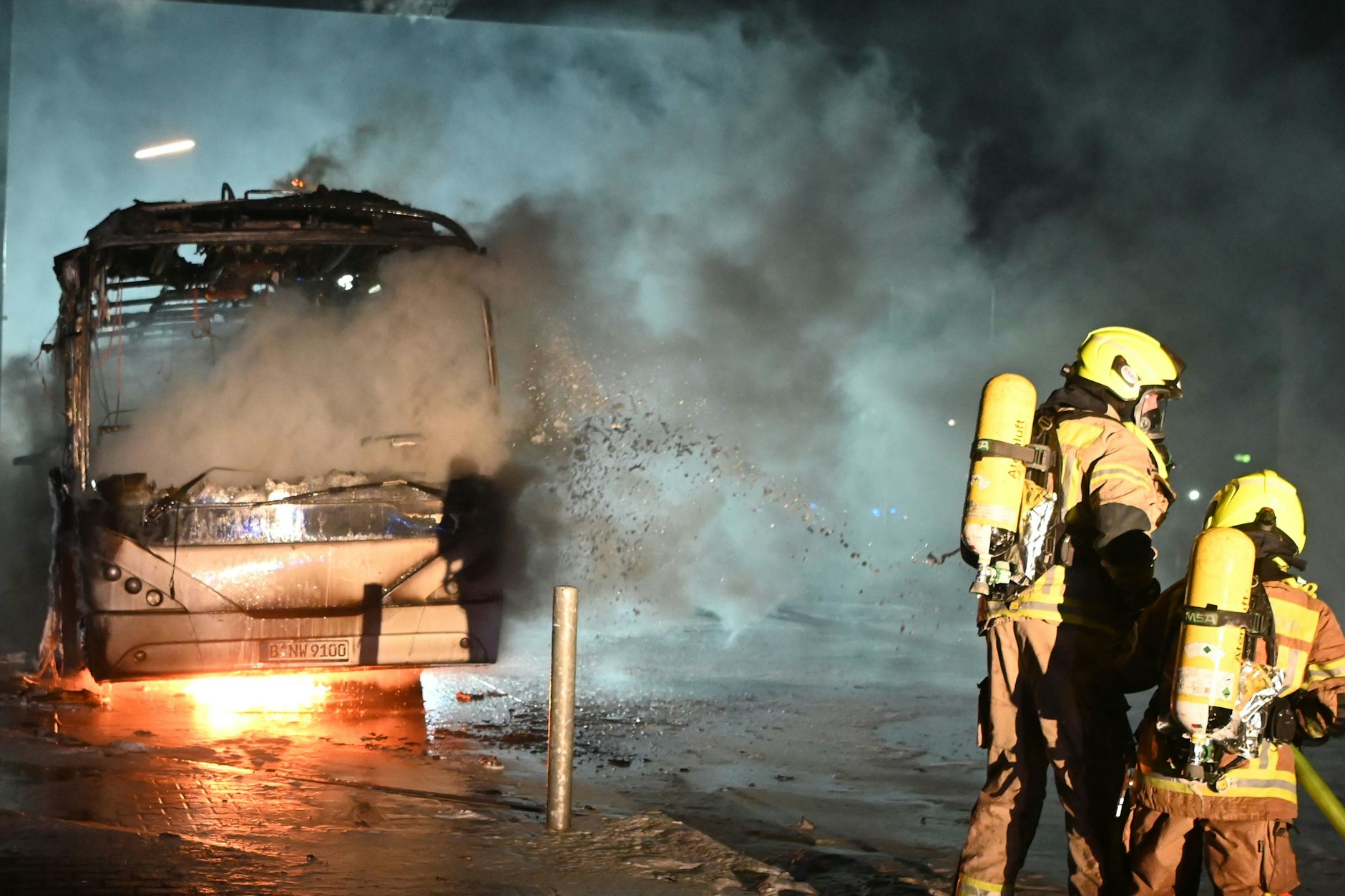 Feuerwehrmänner löschen an der Berliner Sonnenallee einen Reisebus, der in der Silvesternacht von Unbekannten angezündet wurde.