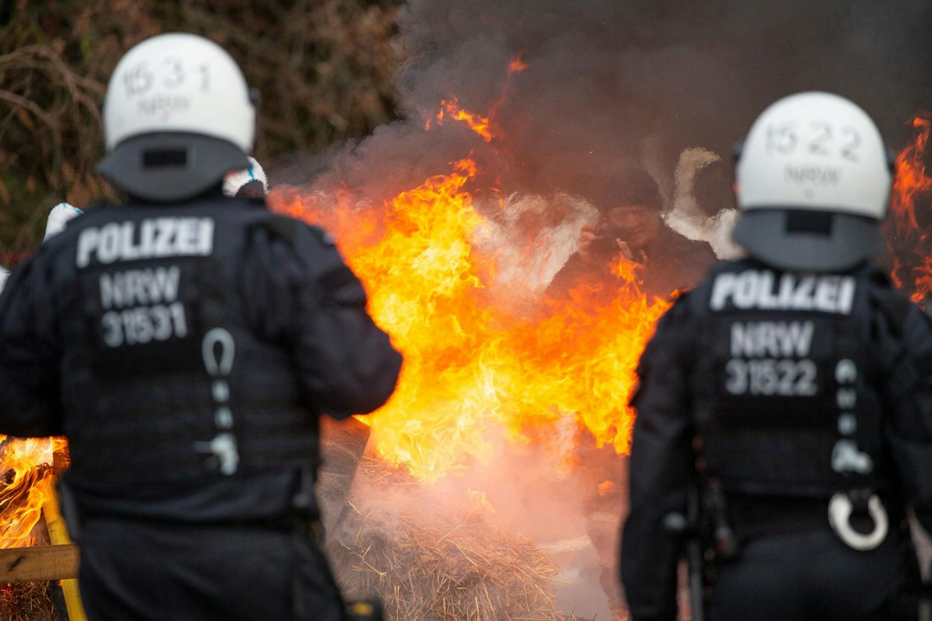 Aktivisten haben Barrikaden aus Strohballen aufgestellt und diese angezündet.