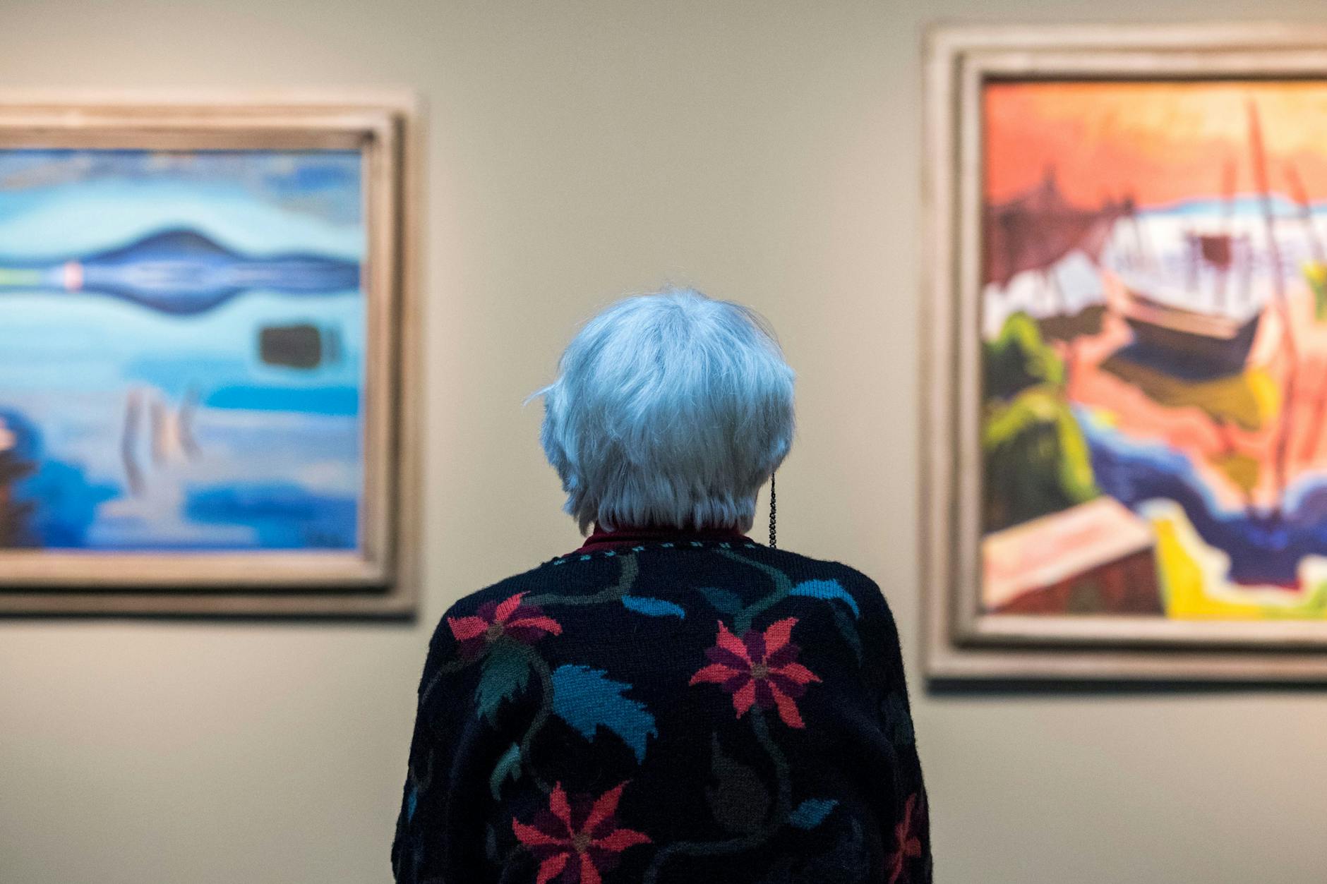 Eine ältere Frau in einer Kunstausstellung.