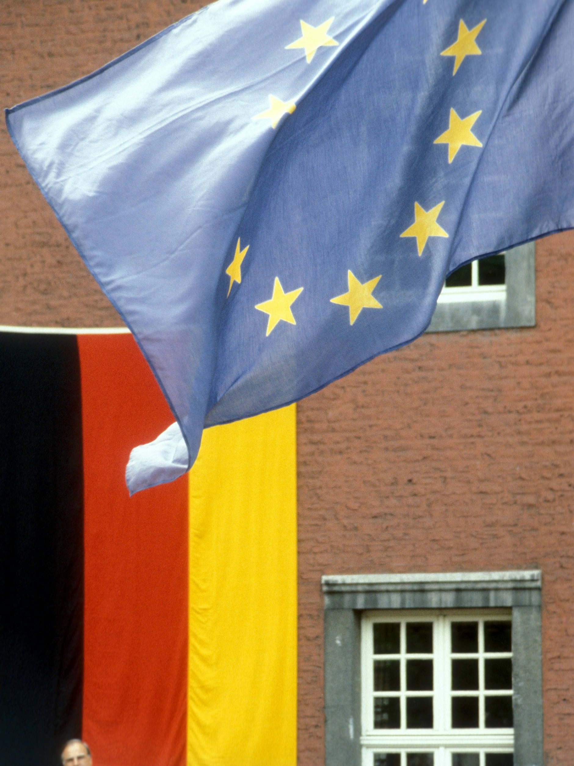 Bundeskanzler Helmut Kohl (li., GER/CDU) unter einer wehenden EU-Flagge, Personen