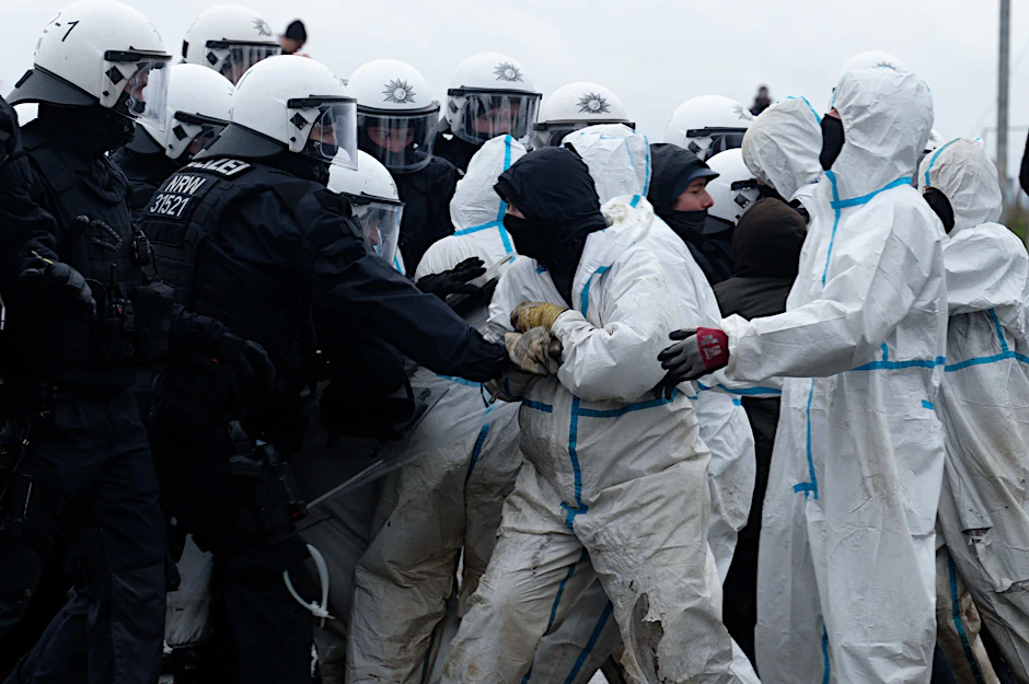 Polizisten drängen Aktivisten von einer Straße zu dem Dorf Lützerath.&nbsp;