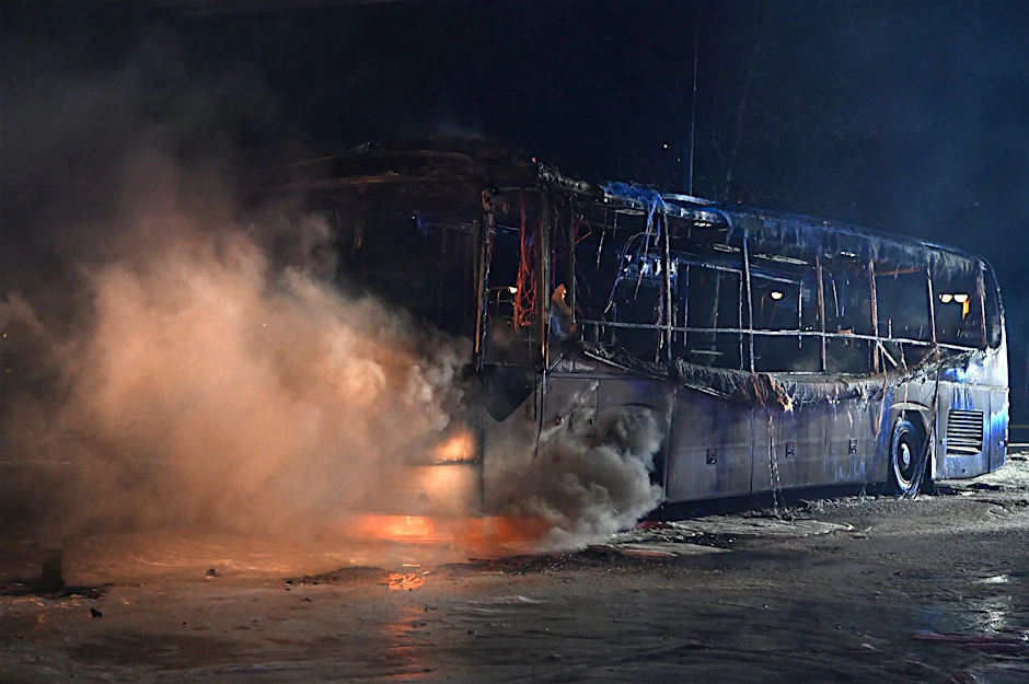 Feuerwehrmänner löschen an der Sonnenallee einen Reisebus, der von Unbekannten angezündet worden war.  