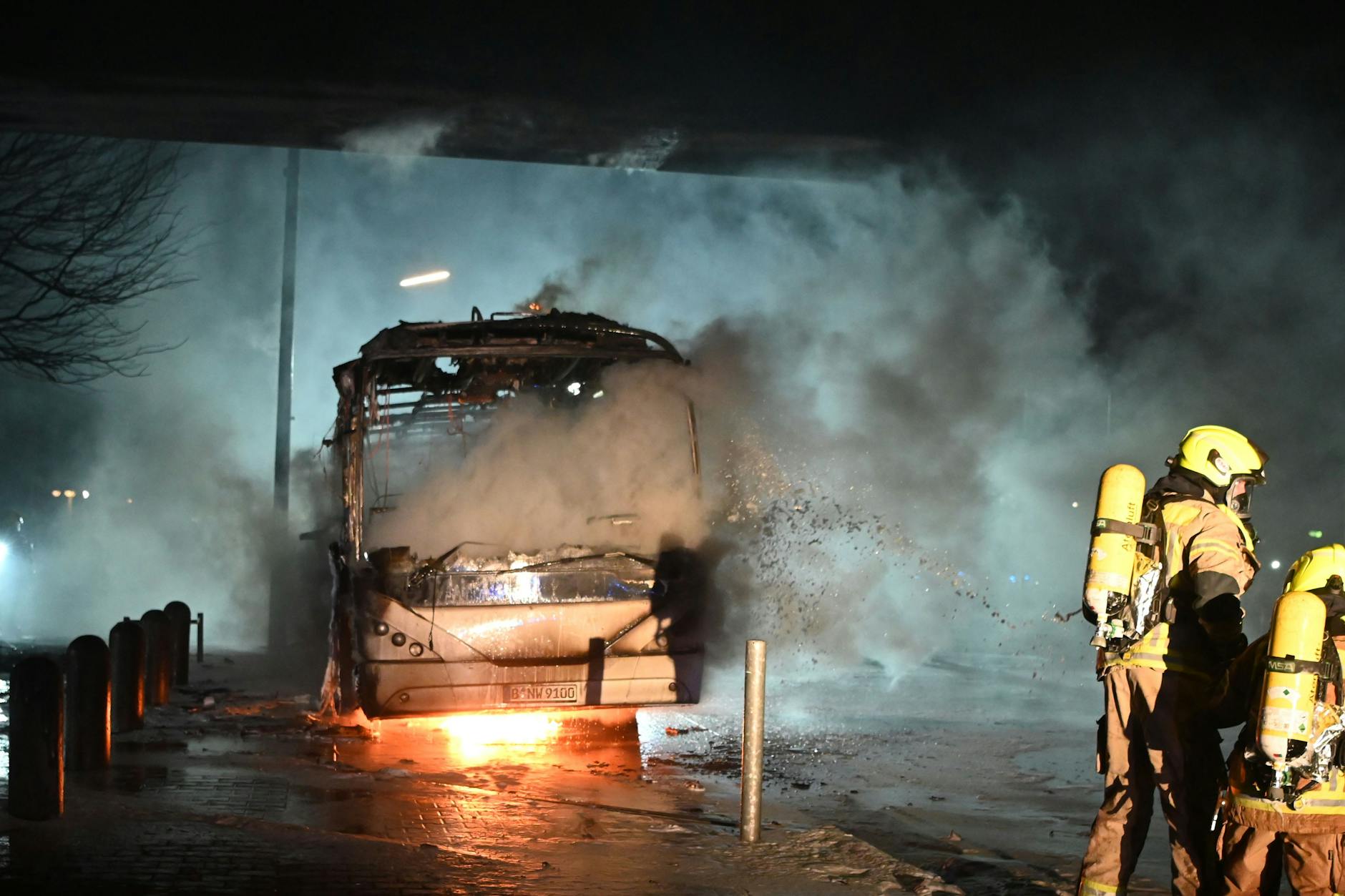 Silvesternacht in Neukölln: Feuerwehrmänner löschen an der Sonnenallee einen Reisebus, der von Unbekannten angezündet worden war.
