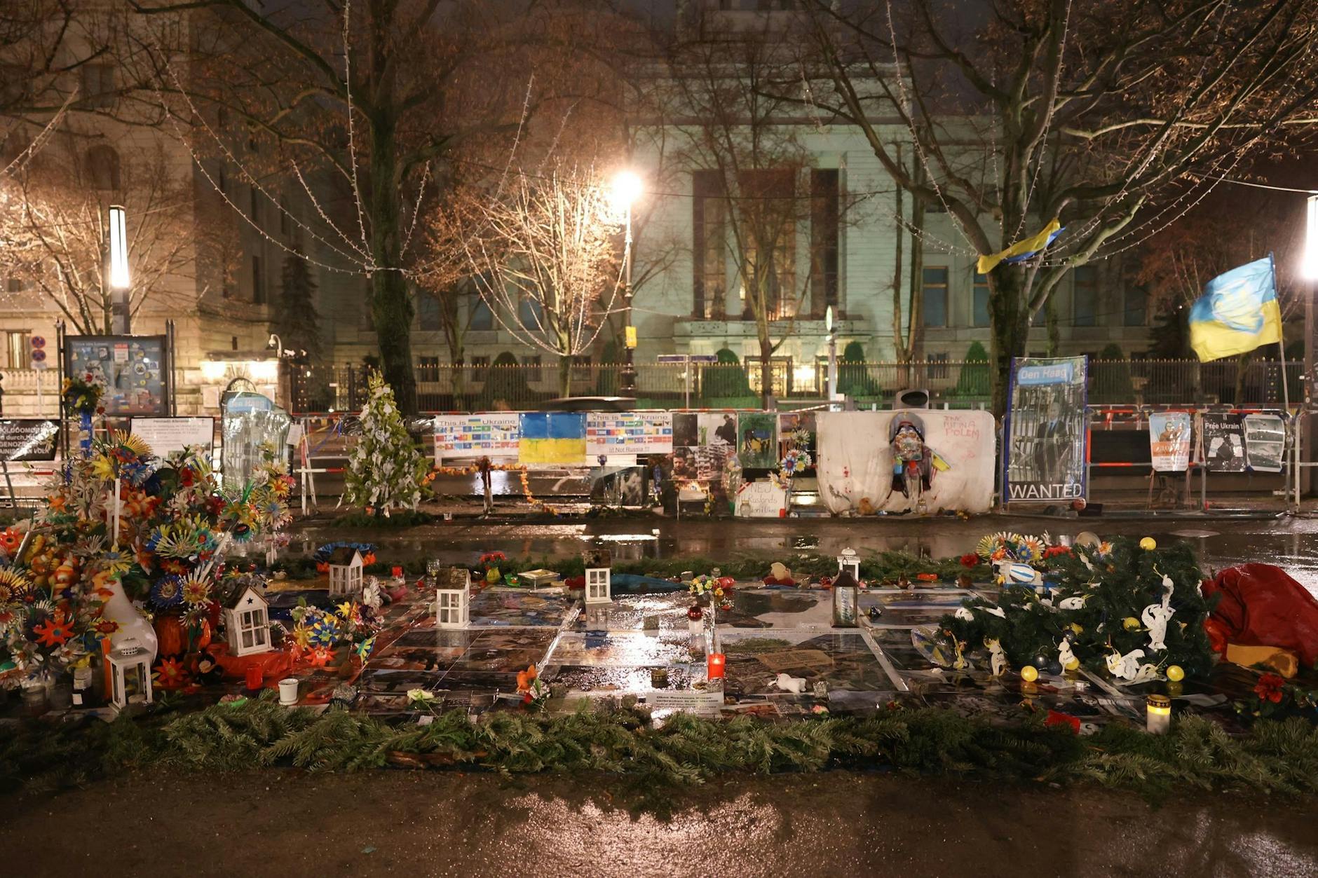 Kerzen, Plakate, Fahnen und andere Zeichen der Trauer und der Solidarität mit der angegriffenen Ukraine liegen vor der Russischen Botschaft Unter den Linden in Berlin.