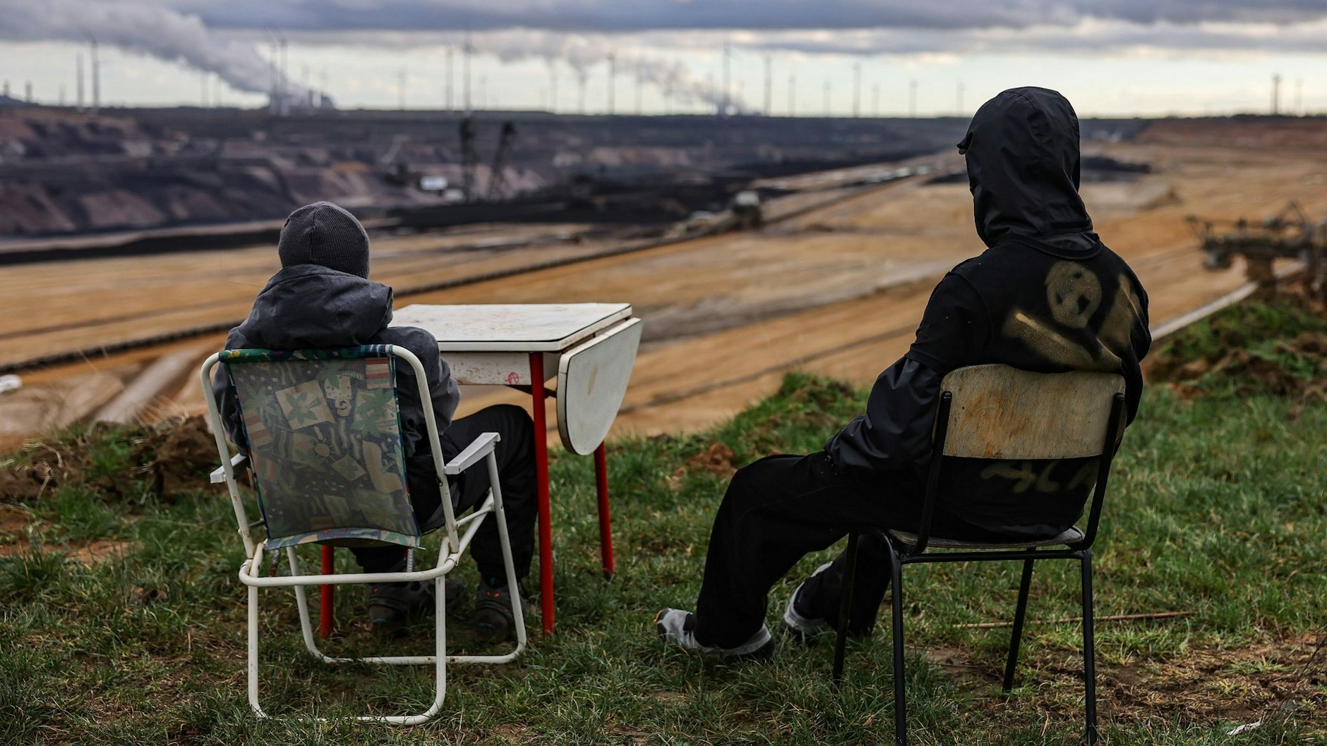 Zwei Aktivisten sitzen am Rande des Braunkohletagebaus in Lützerath.