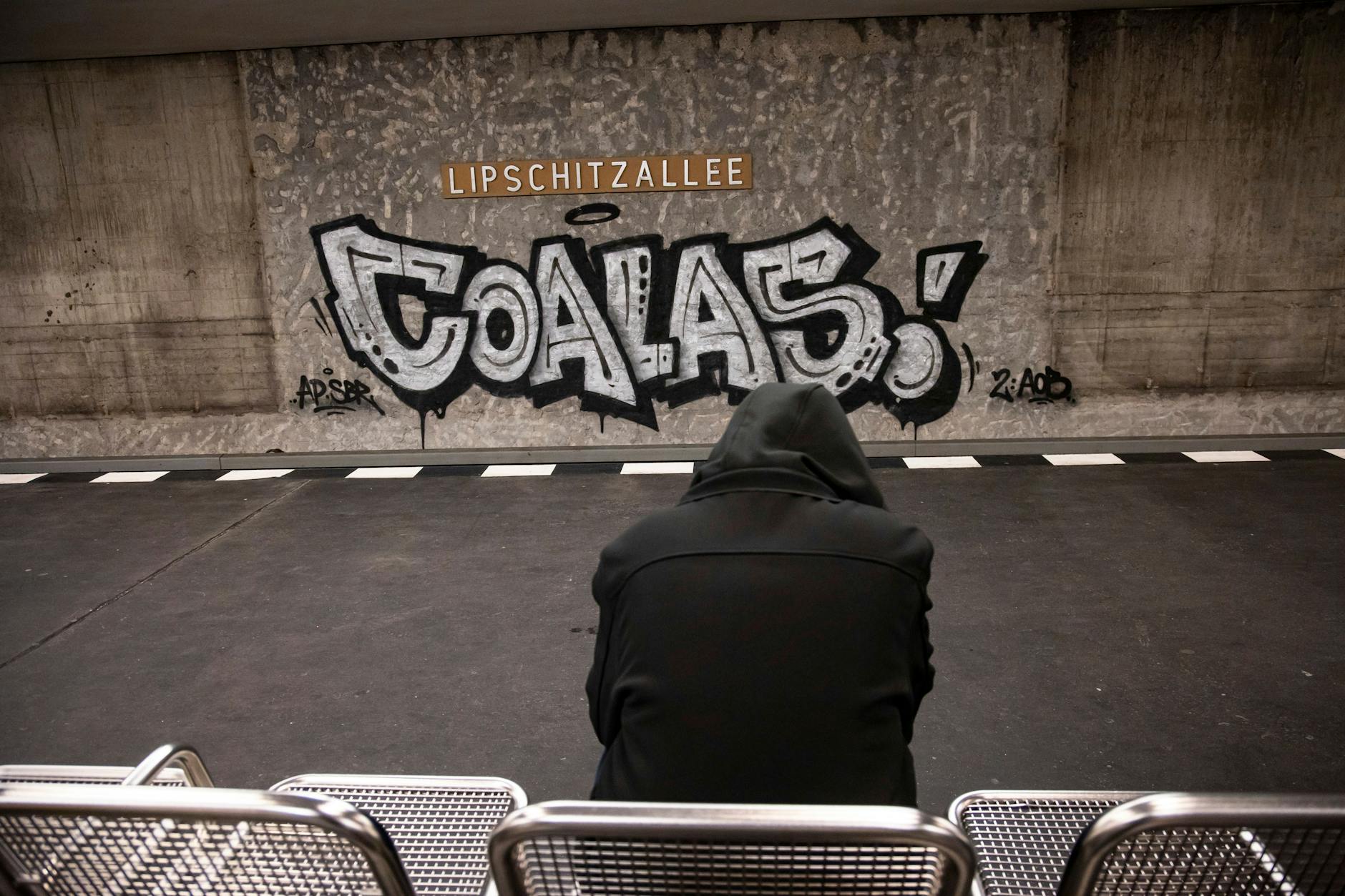 Ein junger Mann wartet auf die Bahn am Bahnhof Lipschitzallee in der Gropiusstadt in Neukölln.