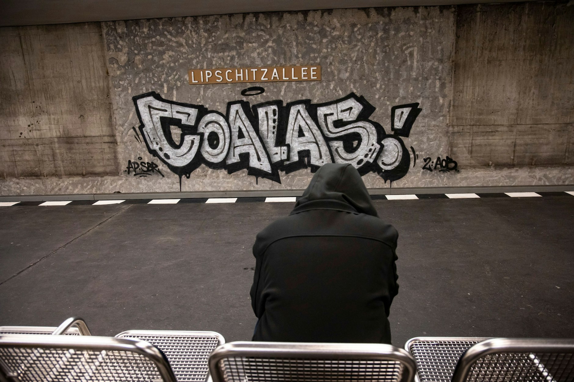 Ein junger Mann wartet auf die Bahn am Bahnhof Lipschitzallee in der Gropiusstadt in Neukölln.