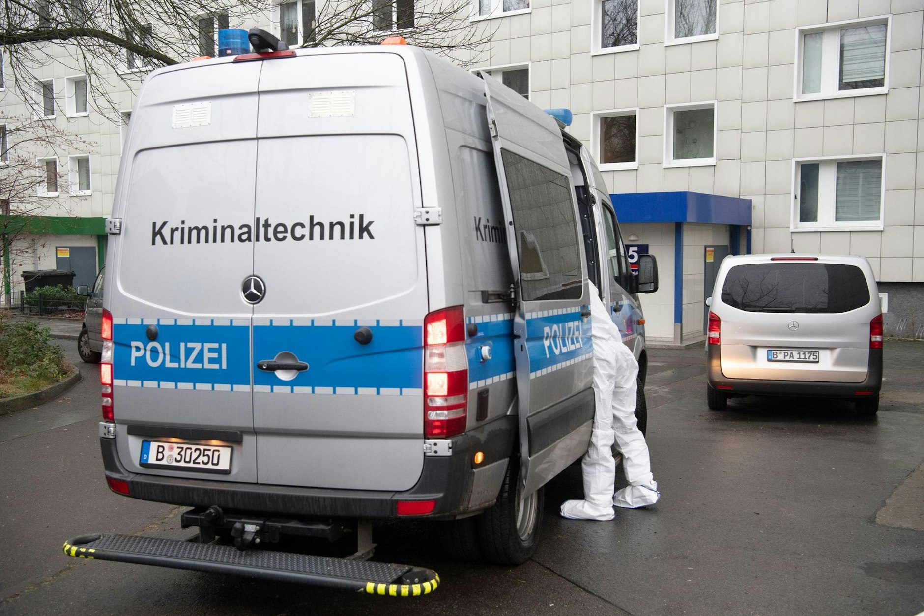 Einsatzkräfte und Fahrzeuge stehen vor einem Haus in Berlin-Lichtenberg.