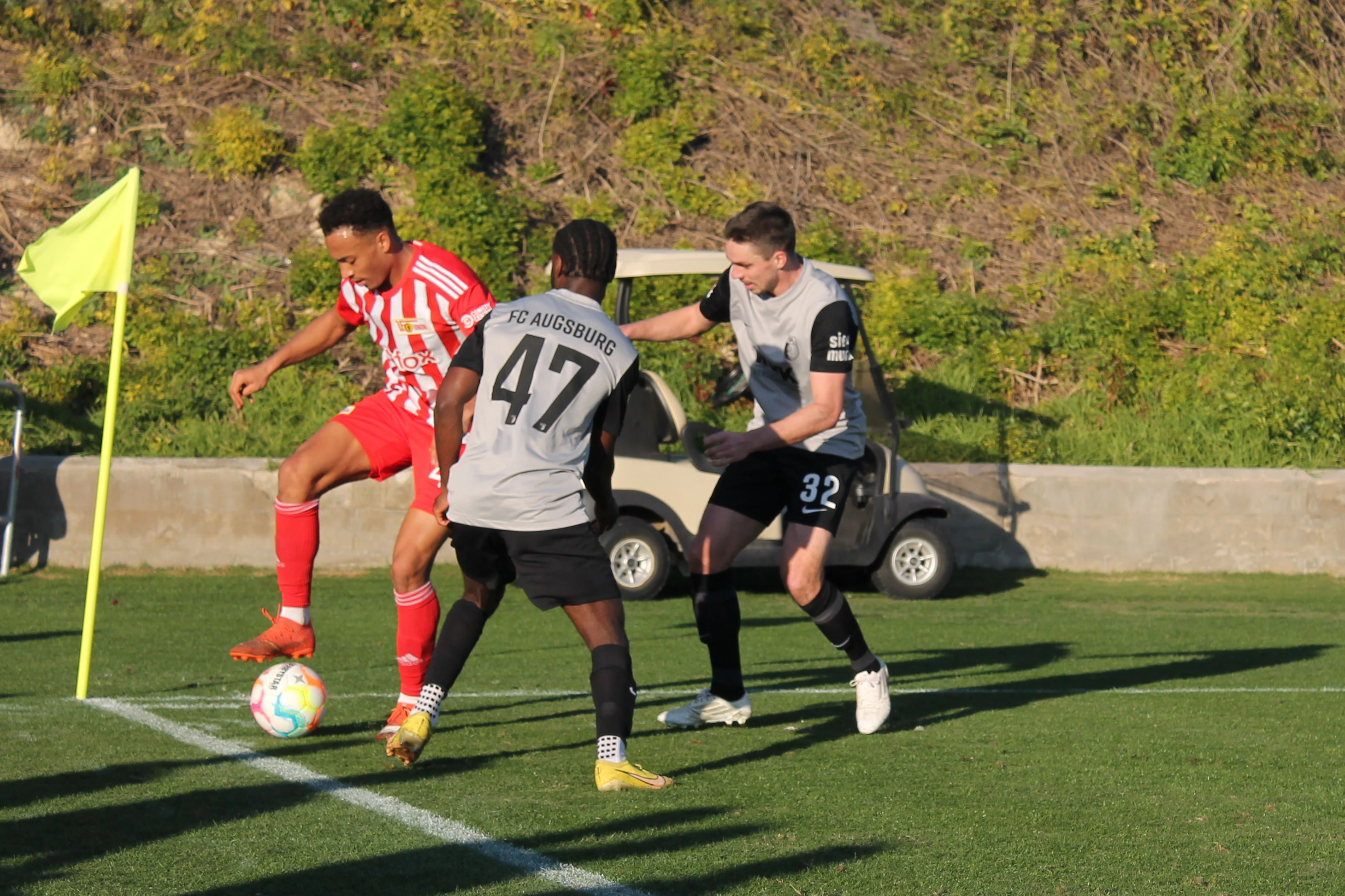Jamie Leweling behauptet den Ball gegen Josué Mbila (M.) und Raphael Framberger.