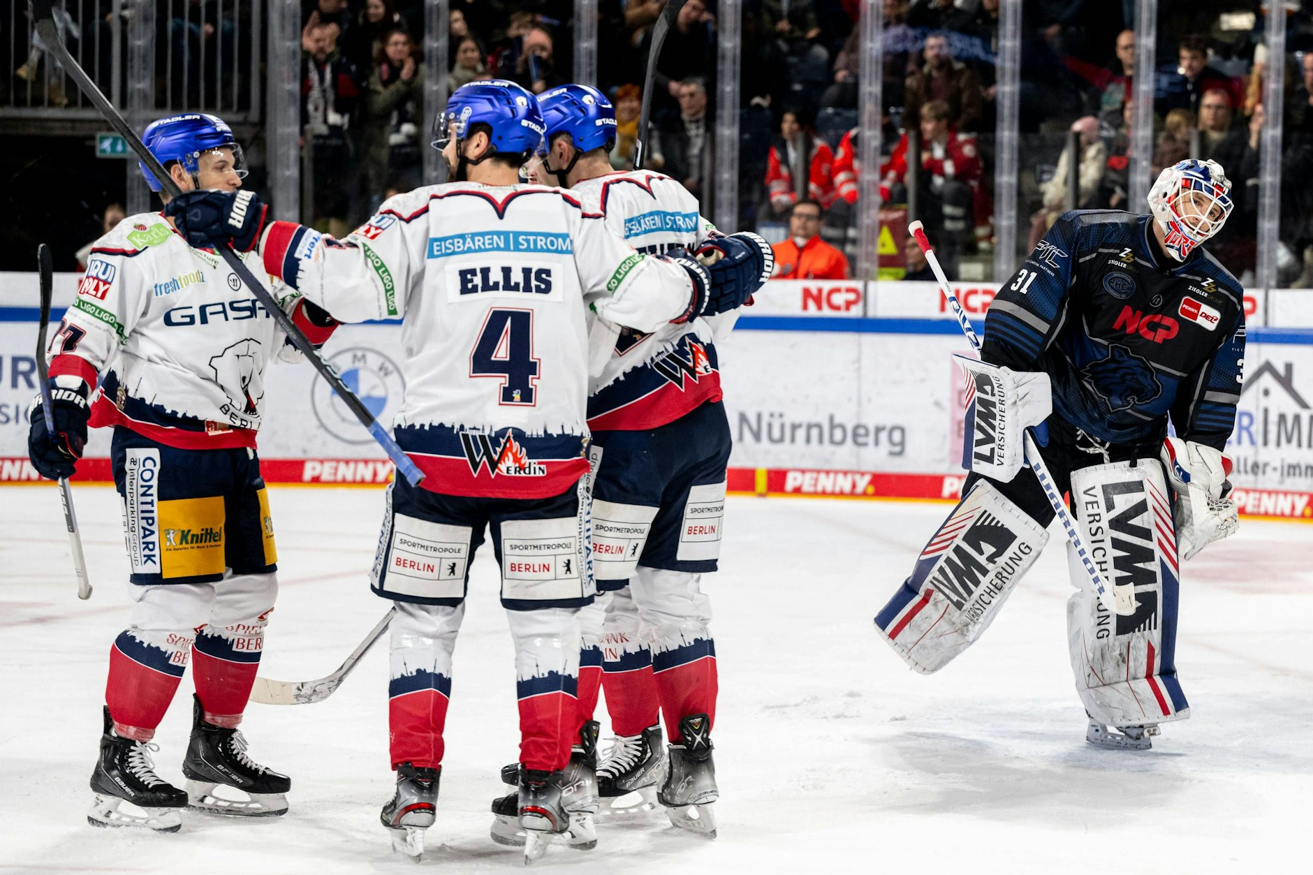Die Eisbären (v.l.) Matt White, Morgan Ellis und Yannick Veilleux feiern in Nürnberg nach dem Tor zum 2:0.