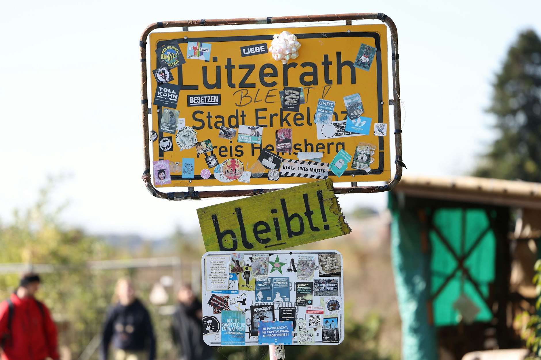 Das von Aktivisten beklebte Dorfeingangs-Schild von Lützerath.