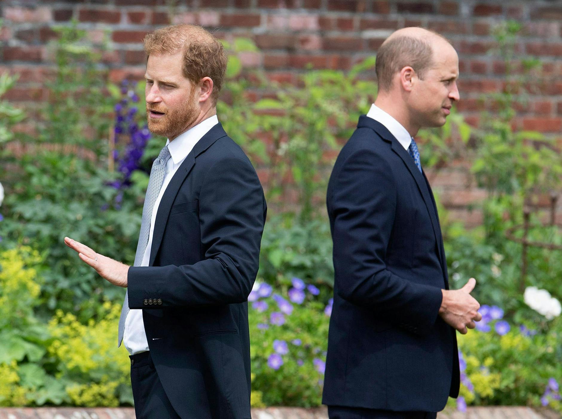 ARCHIV - Die britischen Prinzen Harry (l) und William stehen bei der Enthüllung der Statue ihrer Mutter Diana Rücken an Rücken im Sunken Garden des Kensington-Palastes (2021). dpa