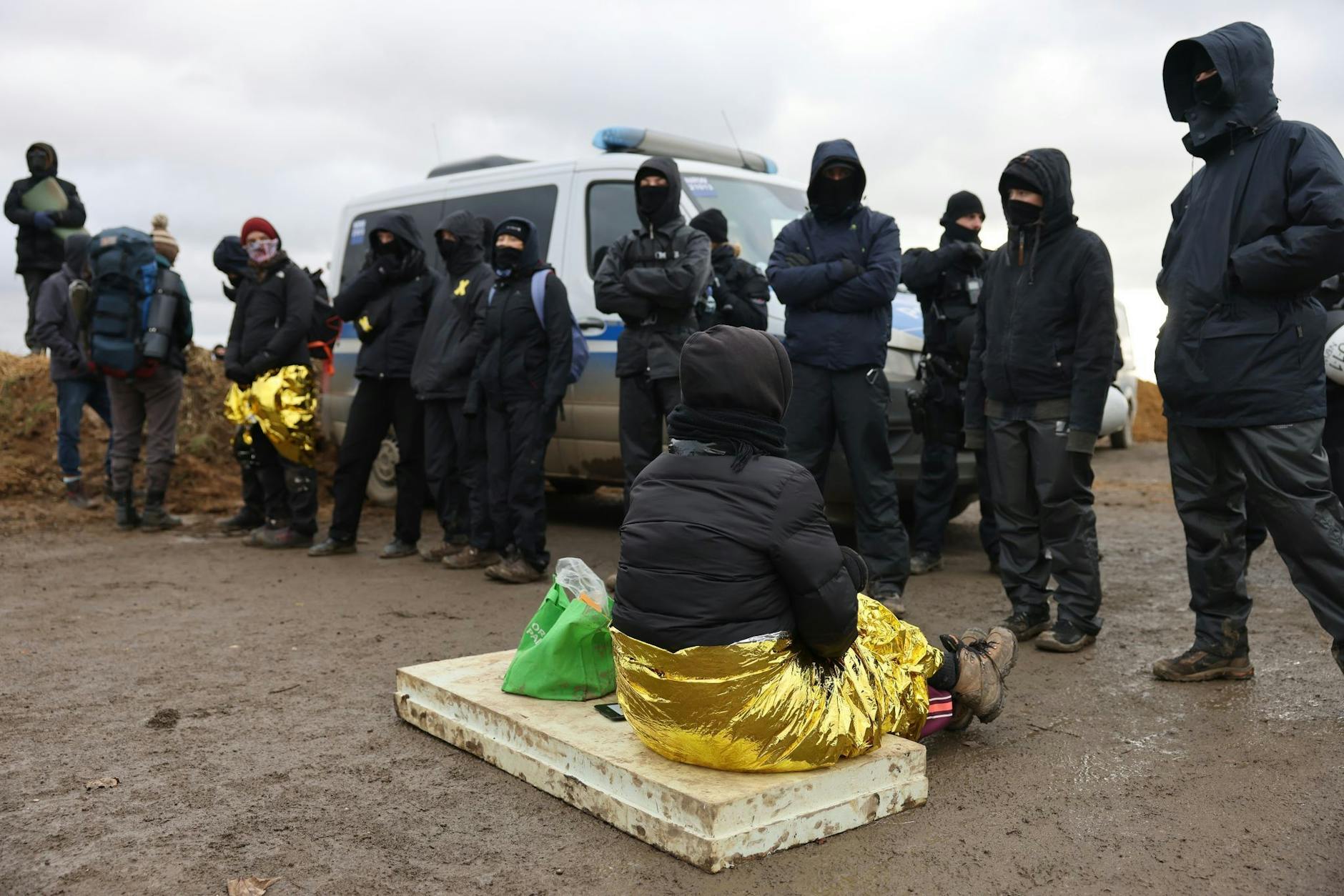 Klimaschutzaktivisten stehen am Rand des Tagebaus und blockieren einen Weg.