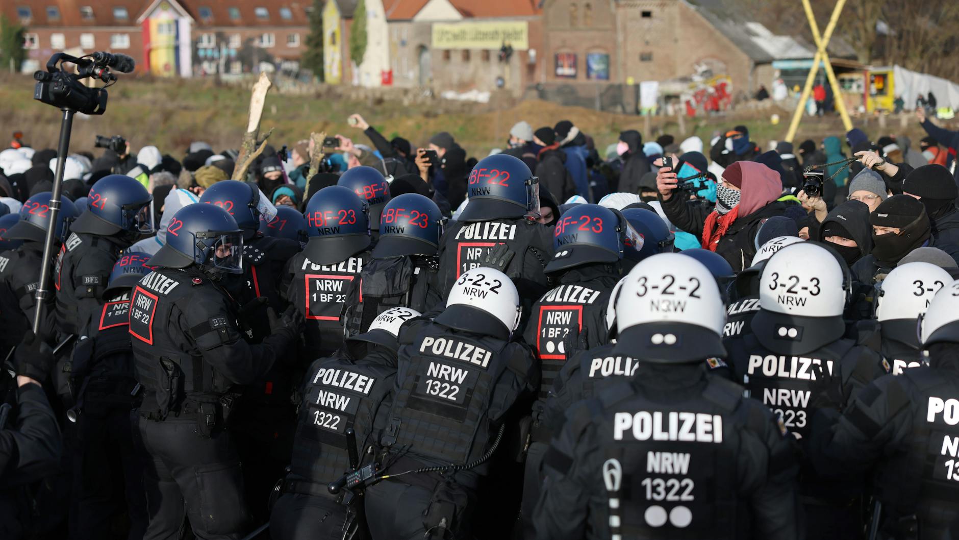 Hat was von American Football: Eine Polizeikette steht Besetzern des Weilers Lützerath (im Hintergrund) gegenüber.