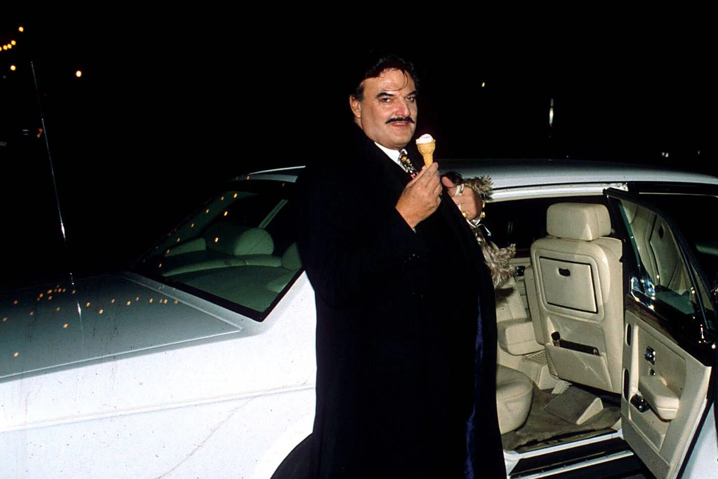 Bunte Krawatte und weißer Rolls Royce: Der Modedesigner Rudolph Moshammer genießt ein Eis im Hörnchen.&nbsp;