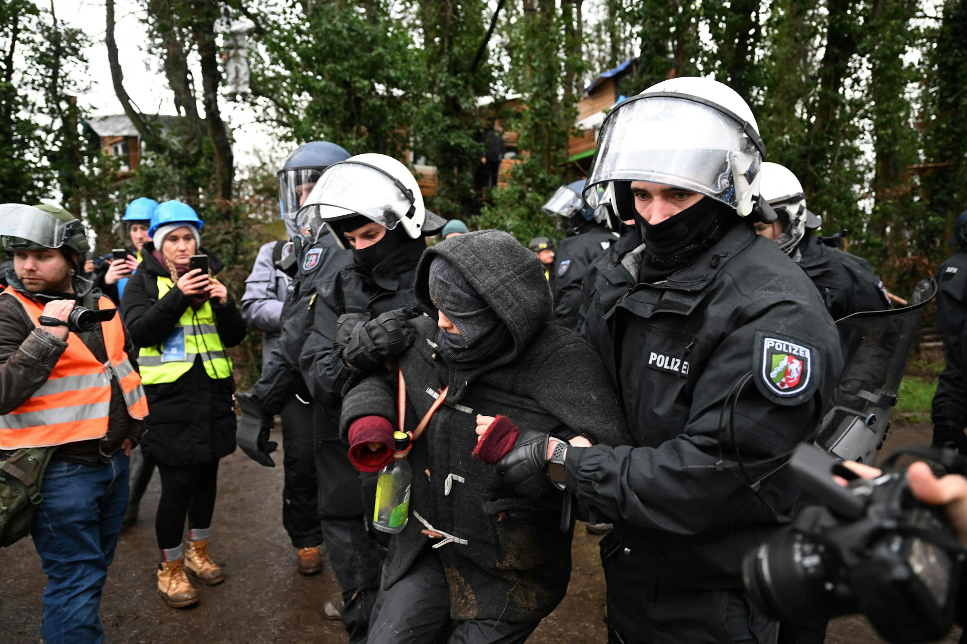 Polizisten entfernen einen Demonstranten vom Gelände, das RWE gehört.
