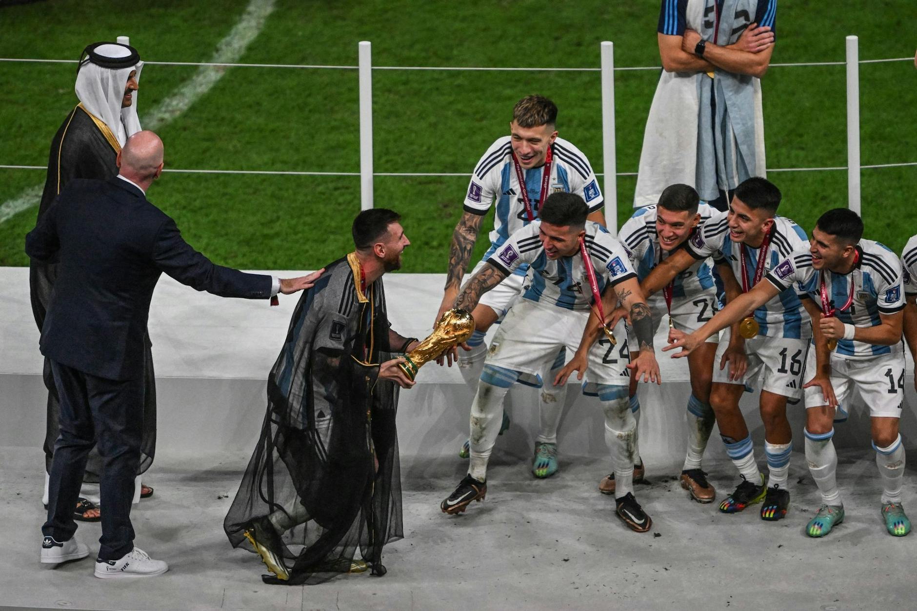 Lionel Messi mit dem WM-Pokal auf dem Weg zu seinen Mannschaftskollegen.