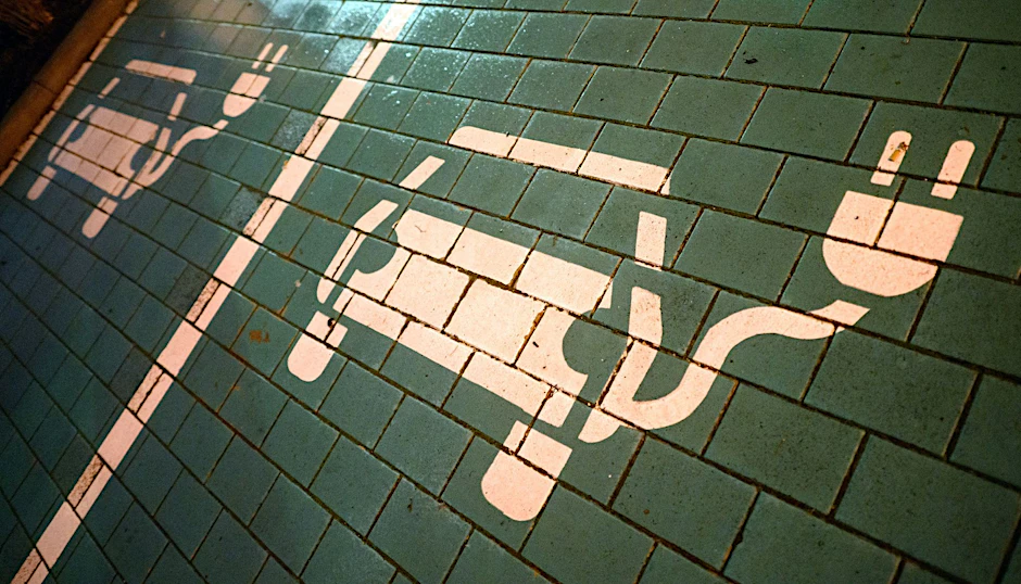 PRODUKTION - Symbole markieren Parkplätze mit einer öffentlichen Ladesäule für Elektroautos.  