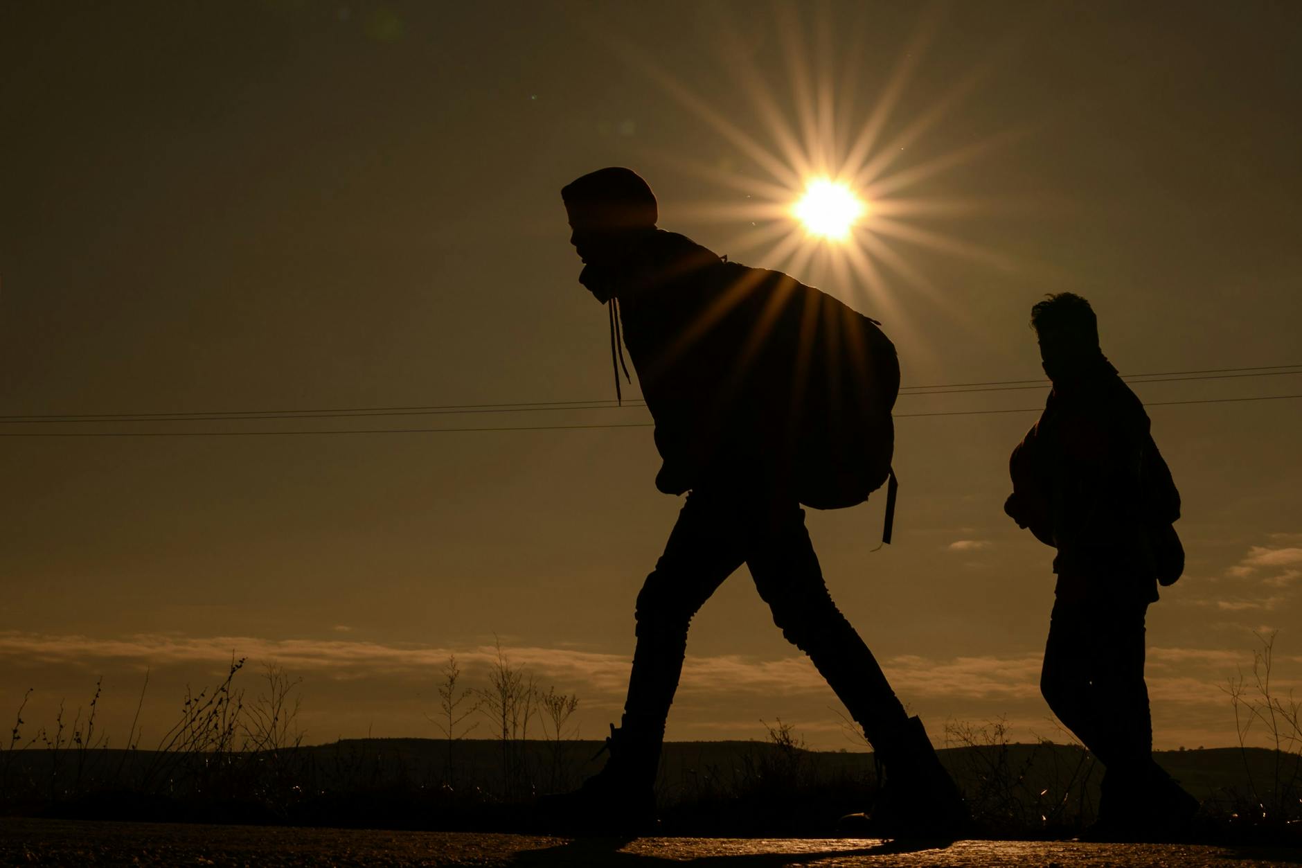 Flüchtlinge aus Afghanistan laufen über eine Landstraße (Symbolbild).