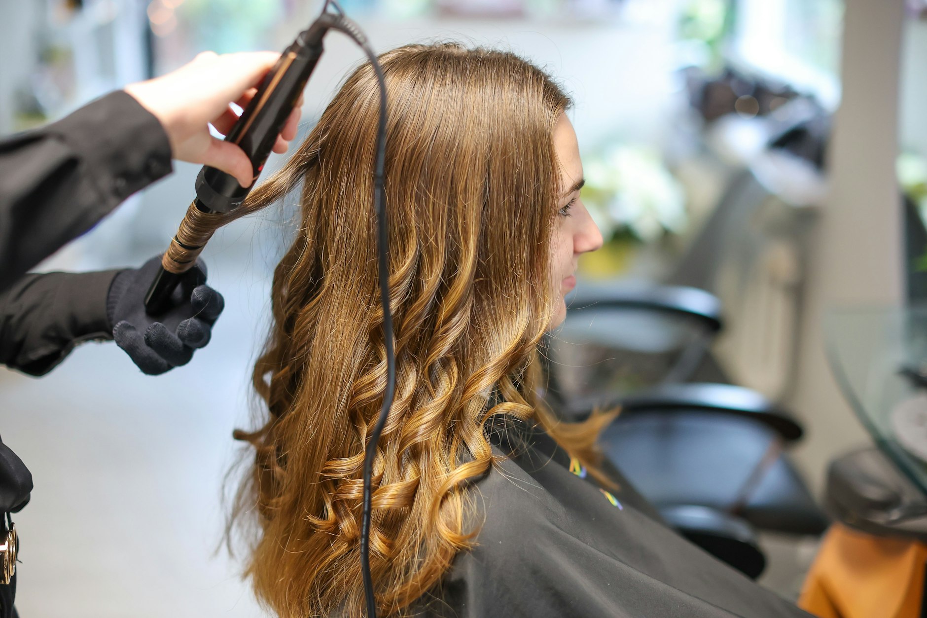 Mit Lockenstab: Eine Friseurin macht ihrer Kundin die Haare.