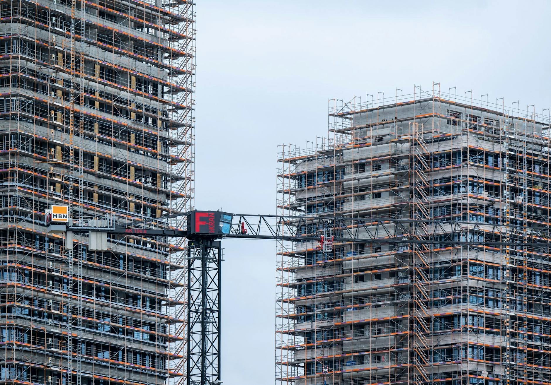 ARCHIV - Ein Baukran auf einer Baustelle zwischen zwei Neubauten unweit vom Ostbahnhof in Berlin.