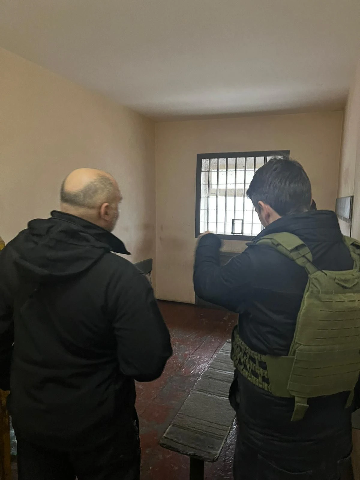 Dr. Marcus Faber und ein ukrainischer Polizist in einer Folterzelle. Hier haben russische Soldaten ukrainische Bürger misshandelt.