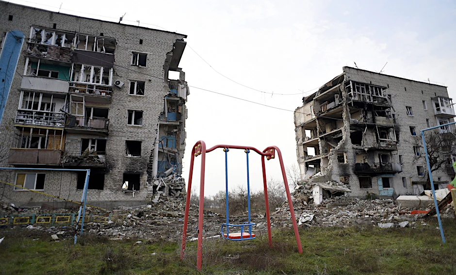 Isjum, in der Region Charkiw. Ein zerstörtes Mehrfamilienhaus mit Spielplatz
