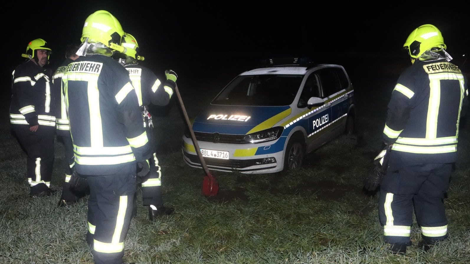 Mit der Schippe war das Polizeiauto nicht zu befreien: Die Räder drehten auf den matschigen Untergrund weiter durch.