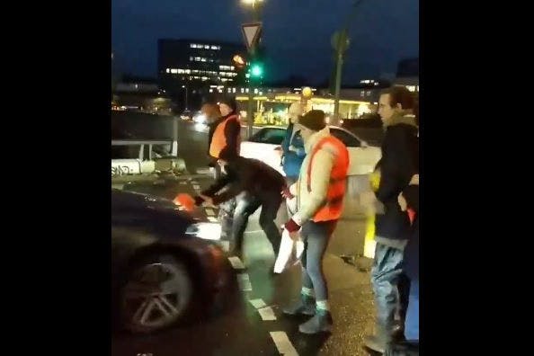 Videoausschnitte zeigen, wie Autofahrer auf Klimaaktivisten zuhalten.