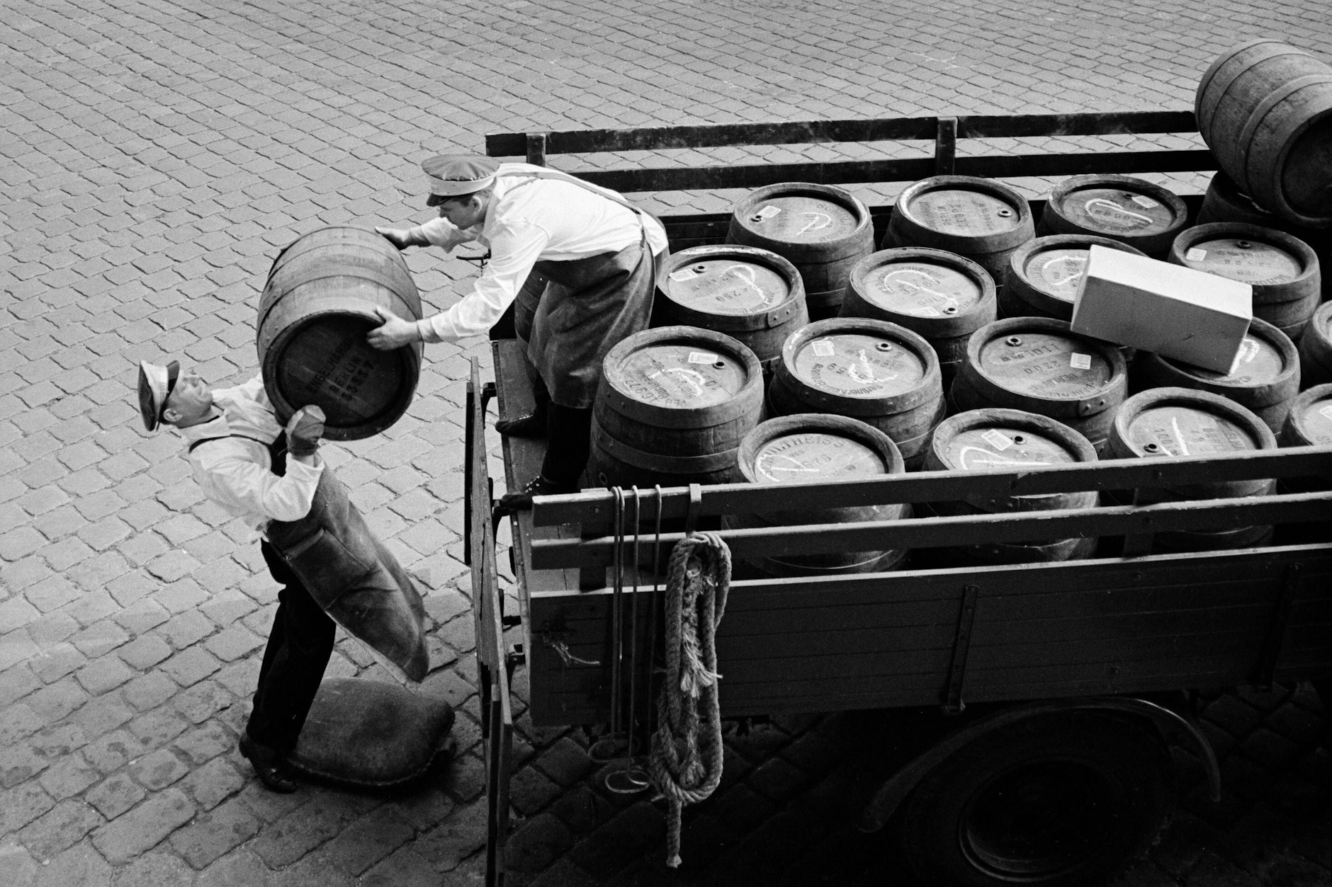 Zu DDR-Zeiten im Berliner Osten: Mitarbeiter einer Brauerei laden Bierfässer von einem Lkw.