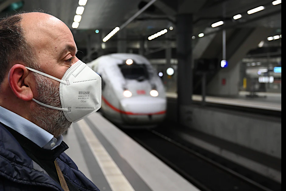 Ein Mann trägt eine Maske am Bahnsteig.