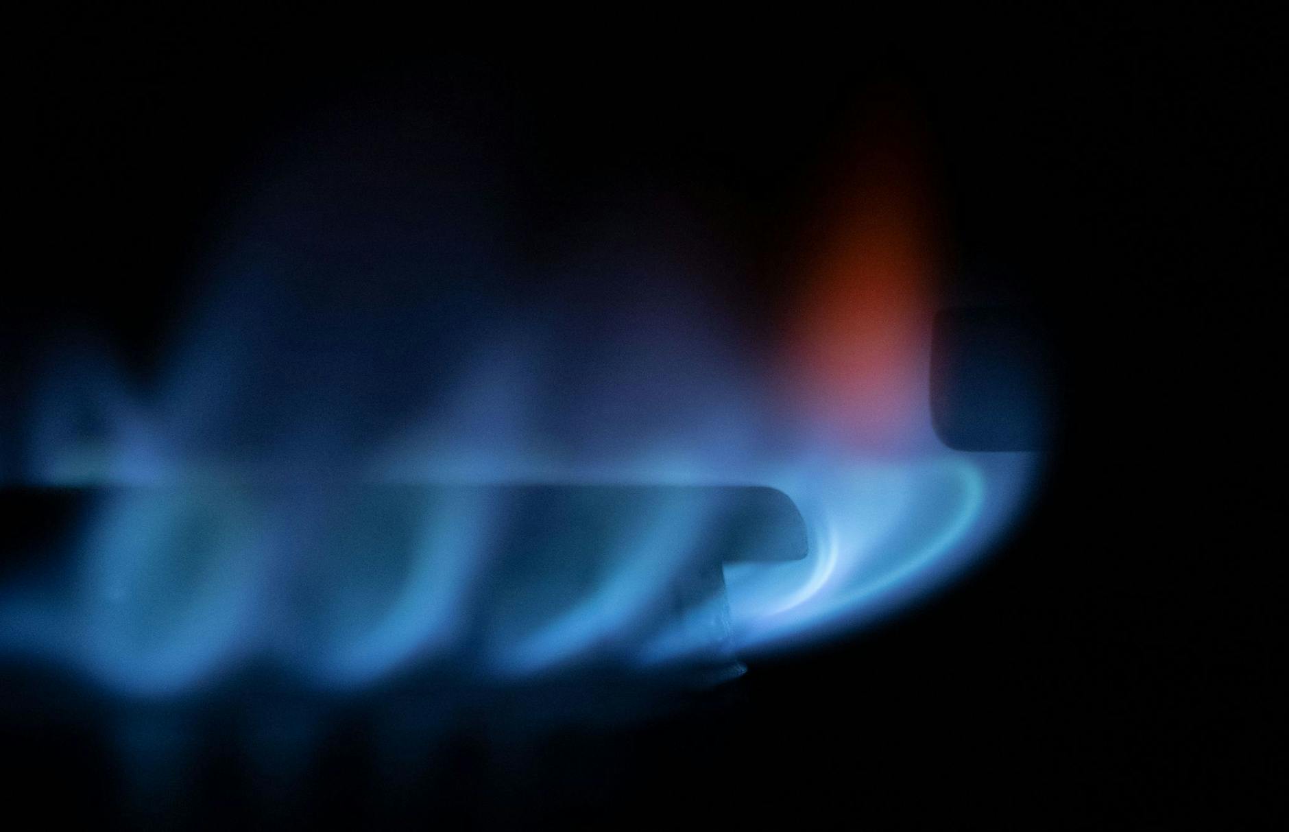 ARCHIV - Zahlreiche blau-schimmernde Gas-Flämmchen sind an einem Gasherd zu sehen.
