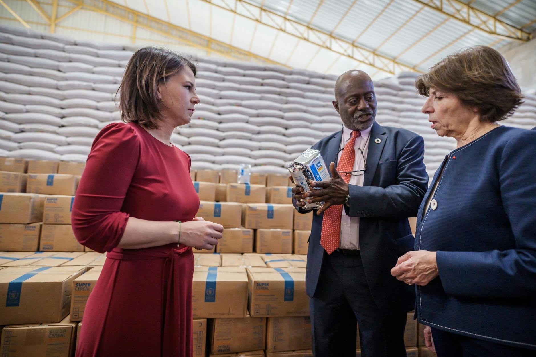 Bundesaußenministerin Annalena Baerbock und ihre französische Amtskollegin Catherine Colonna (r) werden in Adama durch das Getreidelager des UN-Welternährungsprogramms geführt.