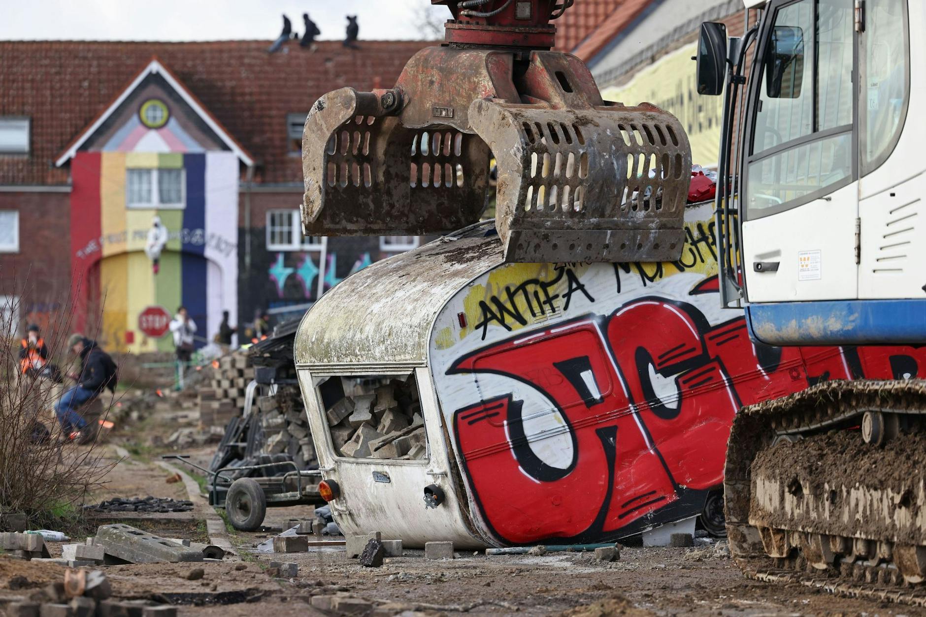 dpatopbilder - Ein Bagger greift bei der Räumung nach einem Wohnwagen.