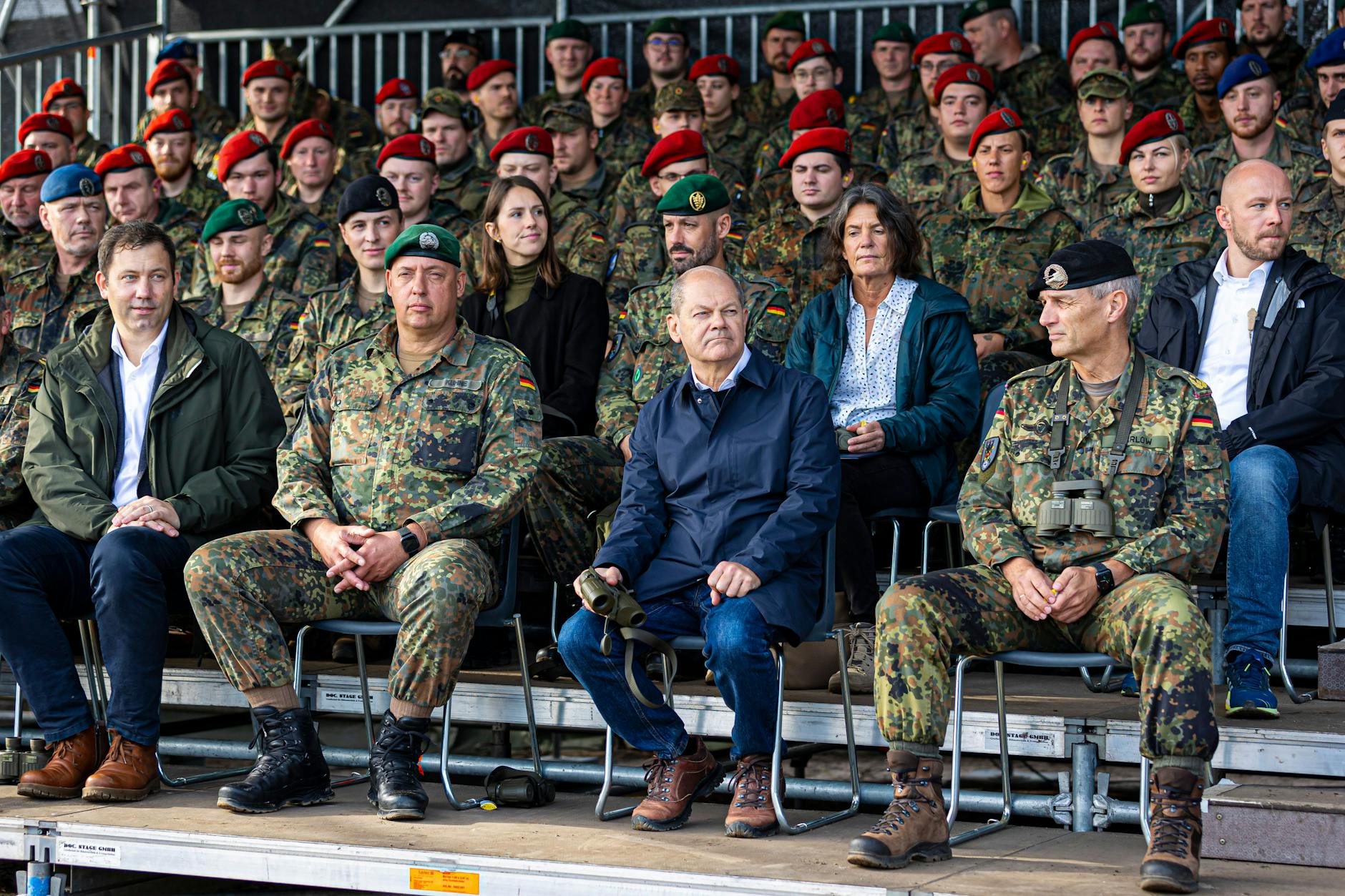 Kanzler Olaf Scholz sitzt kurz vor Beginn einer Ausbildungs- und Lehrübung des Heeres in der Lüneburger Heide auf der Tribüne.