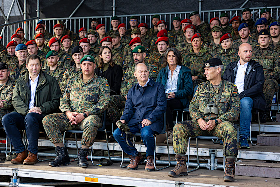 Kanzler Olaf Scholz sitzt kurz vor Beginn einer Ausbildungs- und Lehrübung des Heeres in der Lüneburger Heide auf der Tribüne.