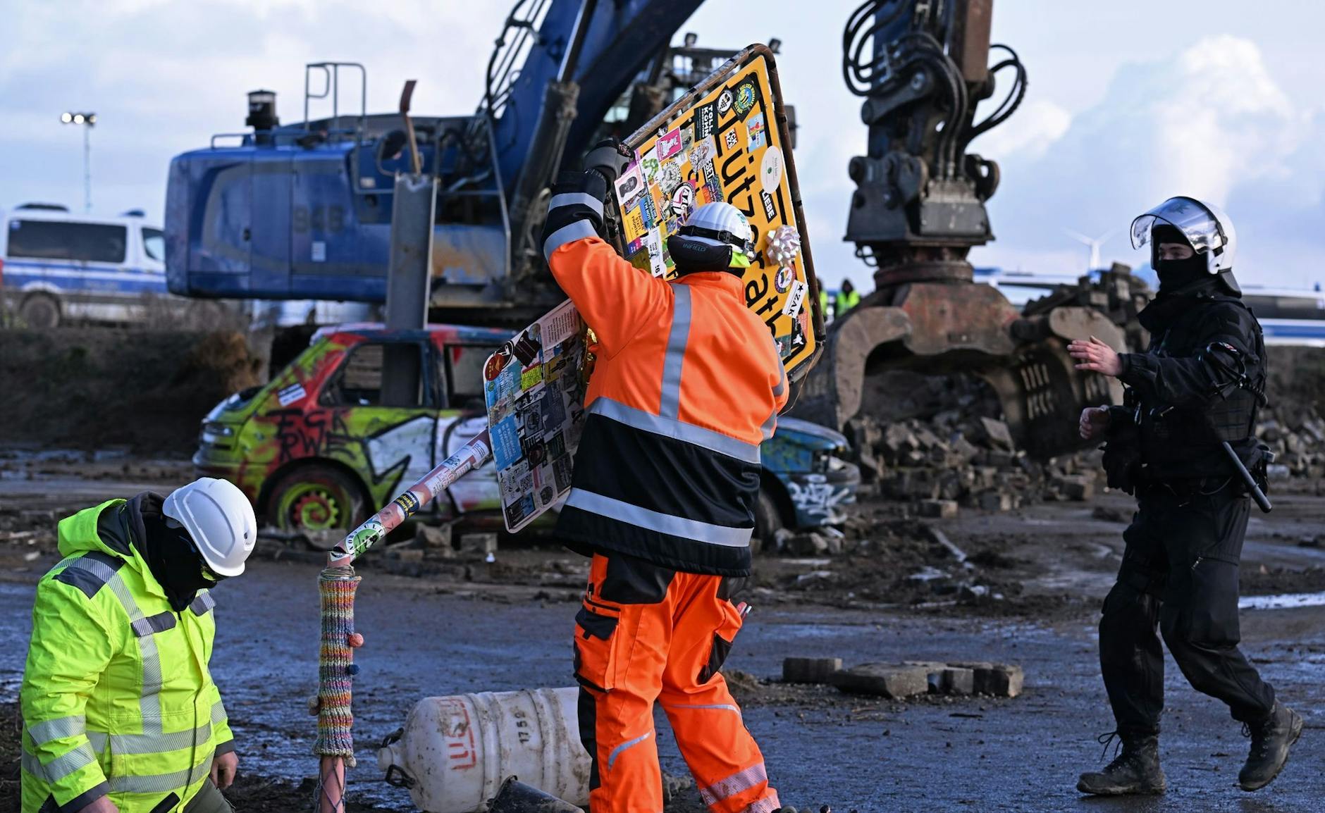 dpatopbilder - RWE-Mitarbeiter entfernen das Ortsschild des Dorfes Lützerath.