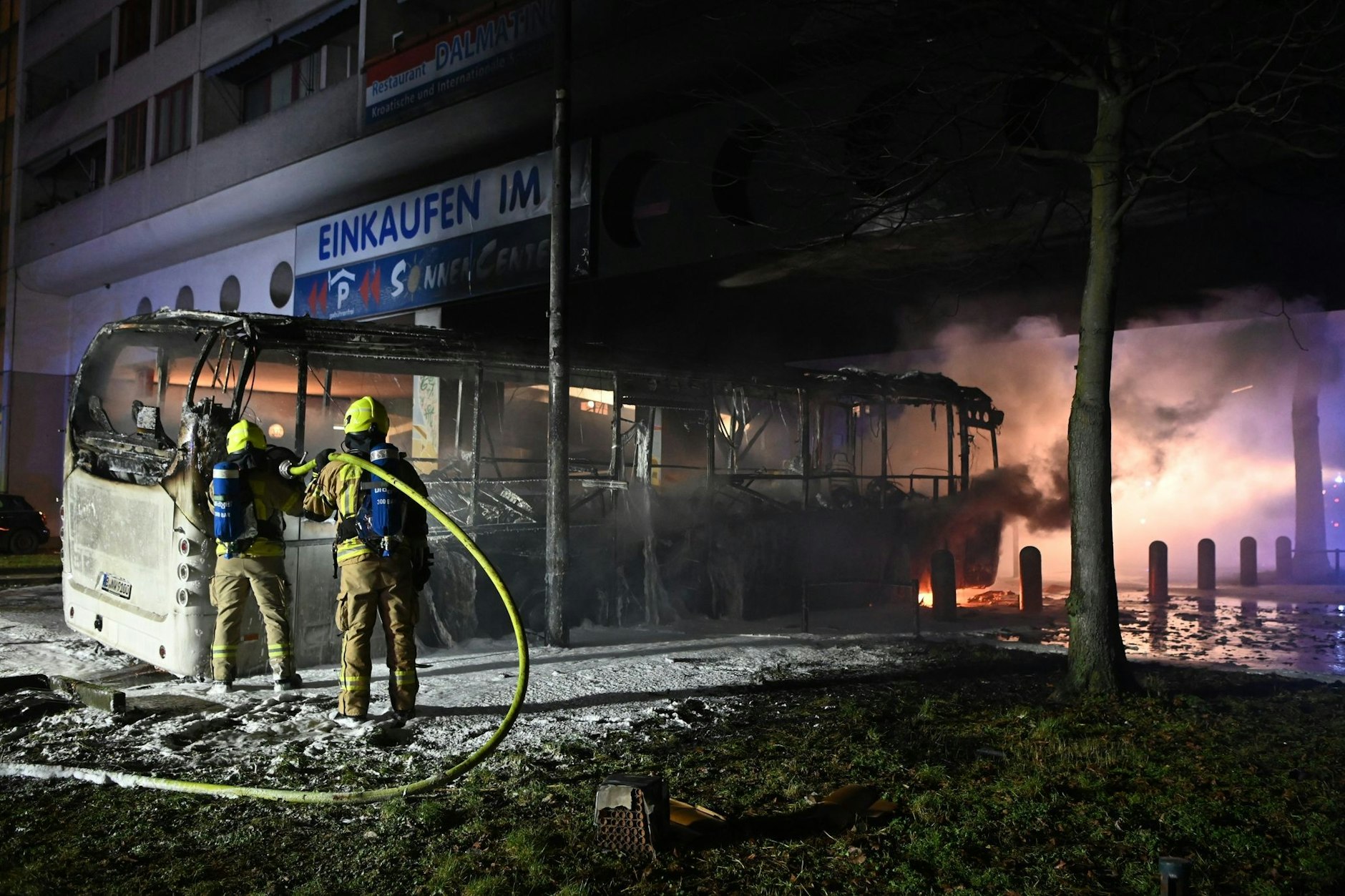 In der Silvesternacht löschen Feuerwehrmänner an der&nbsp;Berliner Sonnenallee einen Reisebus, der von Unbekannten angezündet wurde.&nbsp;