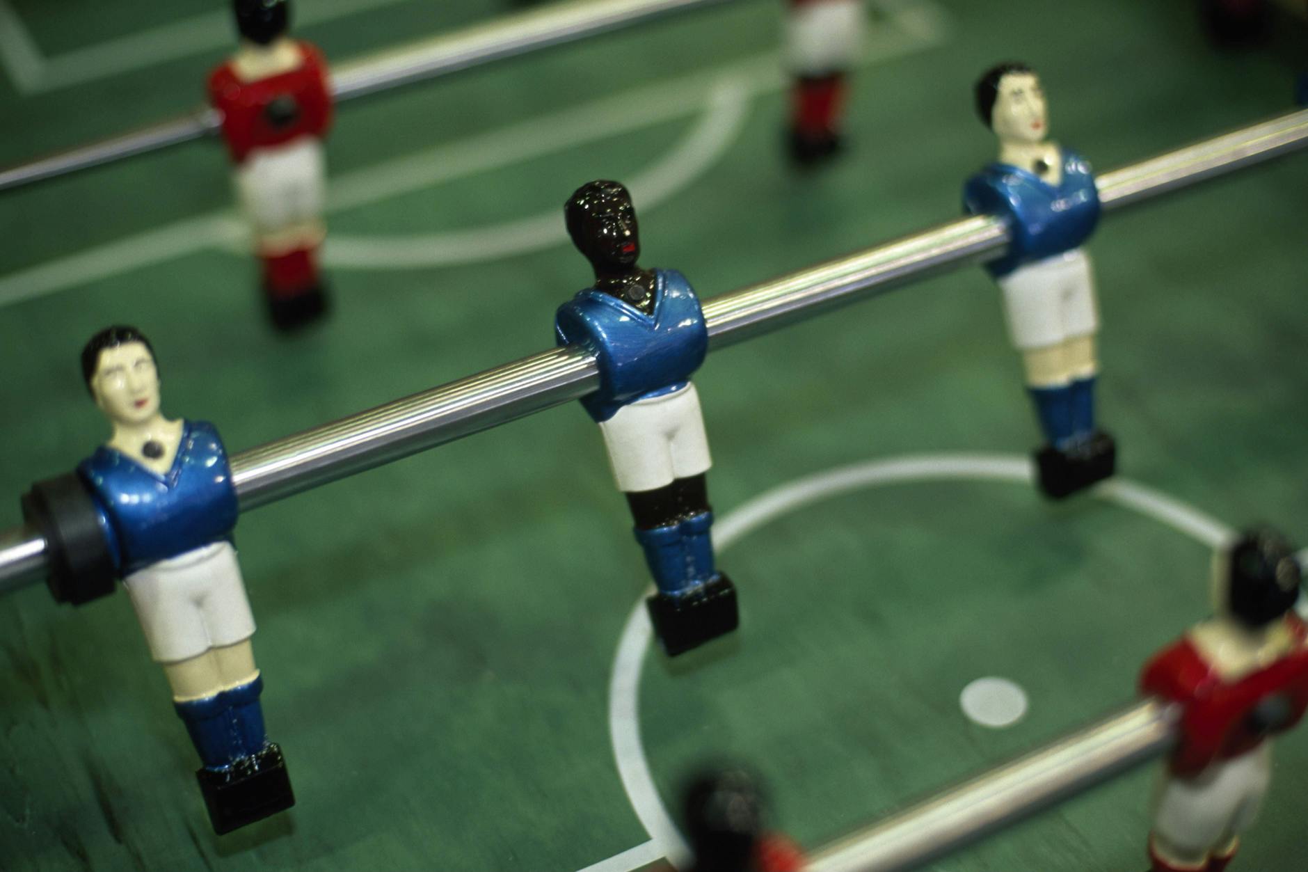 Ein Kickertisch mit weißen und schwarzen Spielfiguren.