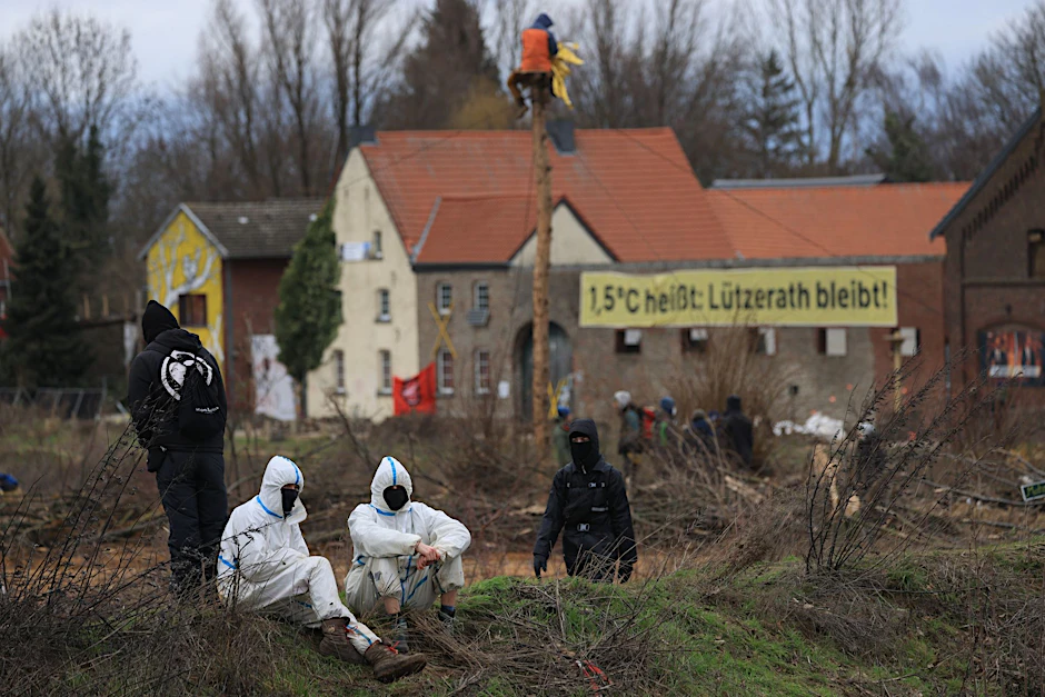 Klimaschutzaktivisten sitzen am Dorfrand von Lützerath.  