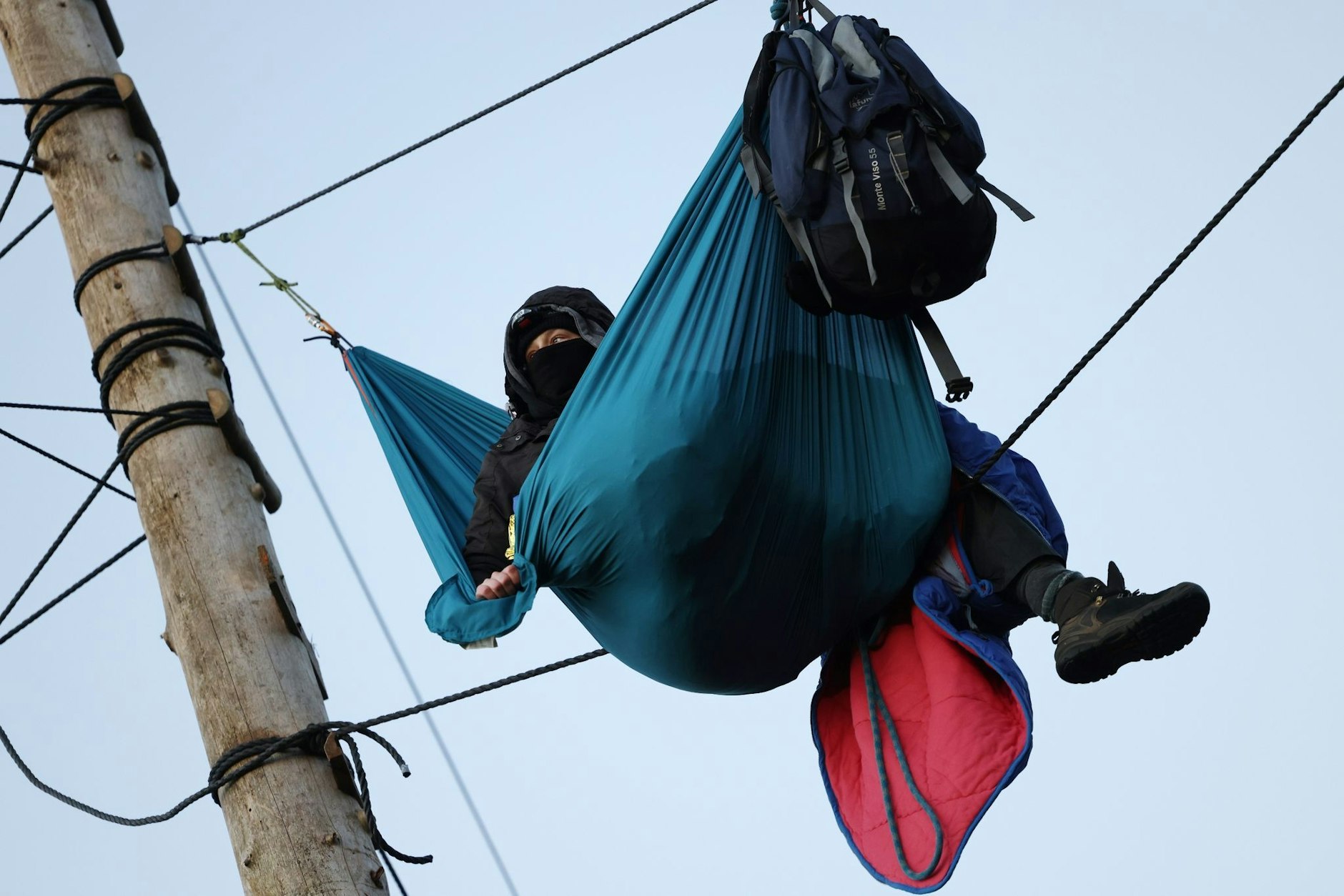 Ein Aktivist am Morgen des dritten Tages der Räumung des von Klimaaktivisten besetzten Braunkohleorts Lützerath in seiner Hängematte.  