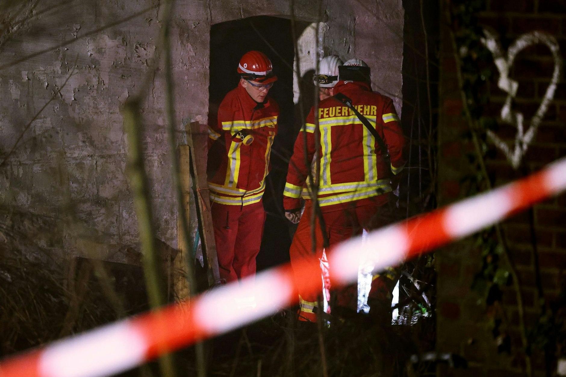 Rettungskräfte beraten vor eine Gebäude, in dem sich Personen in einem Tunnel verschanzt haben.  