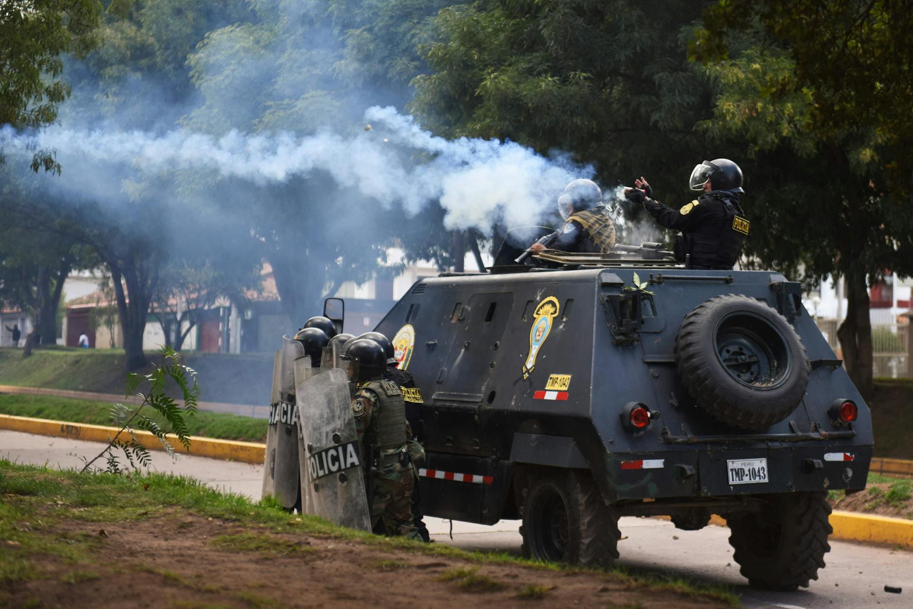 Peruanische Polizisten feuern Tränengas auf Demonstranten.