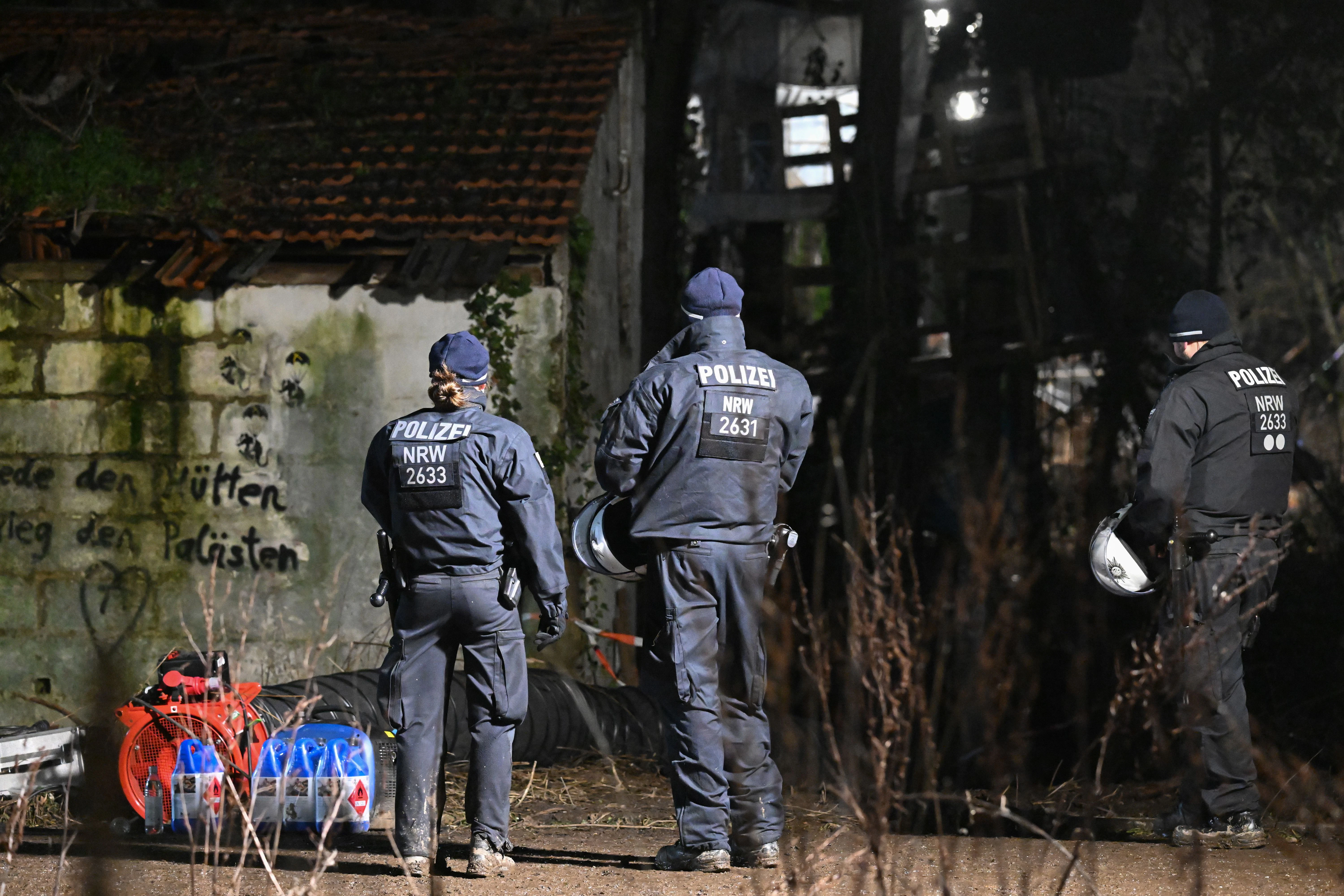 Polizisten stehen in Lützerath vor dem Gebäude, in dem sich der Eingang zu dem Tunnel befinden soll, in dem sich zwei Klimaaktivisten verschanzt haben.