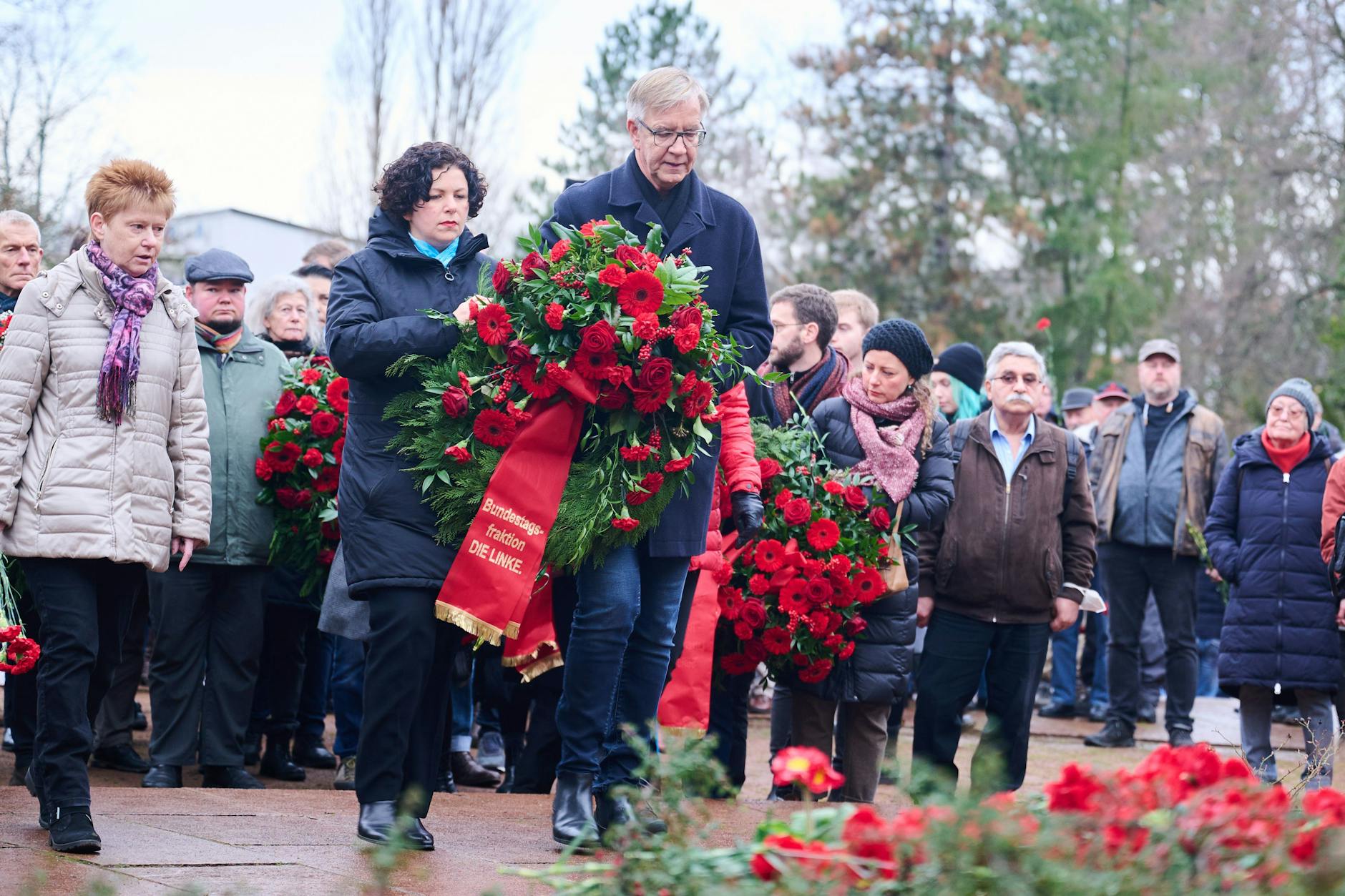 Die Linke-Fraktionsvorsitzenden Amira Mohamed Ali und Dietmar Bartsch legen auf dem Friedhof in Friedrichsfelde einen Kranz nieder.